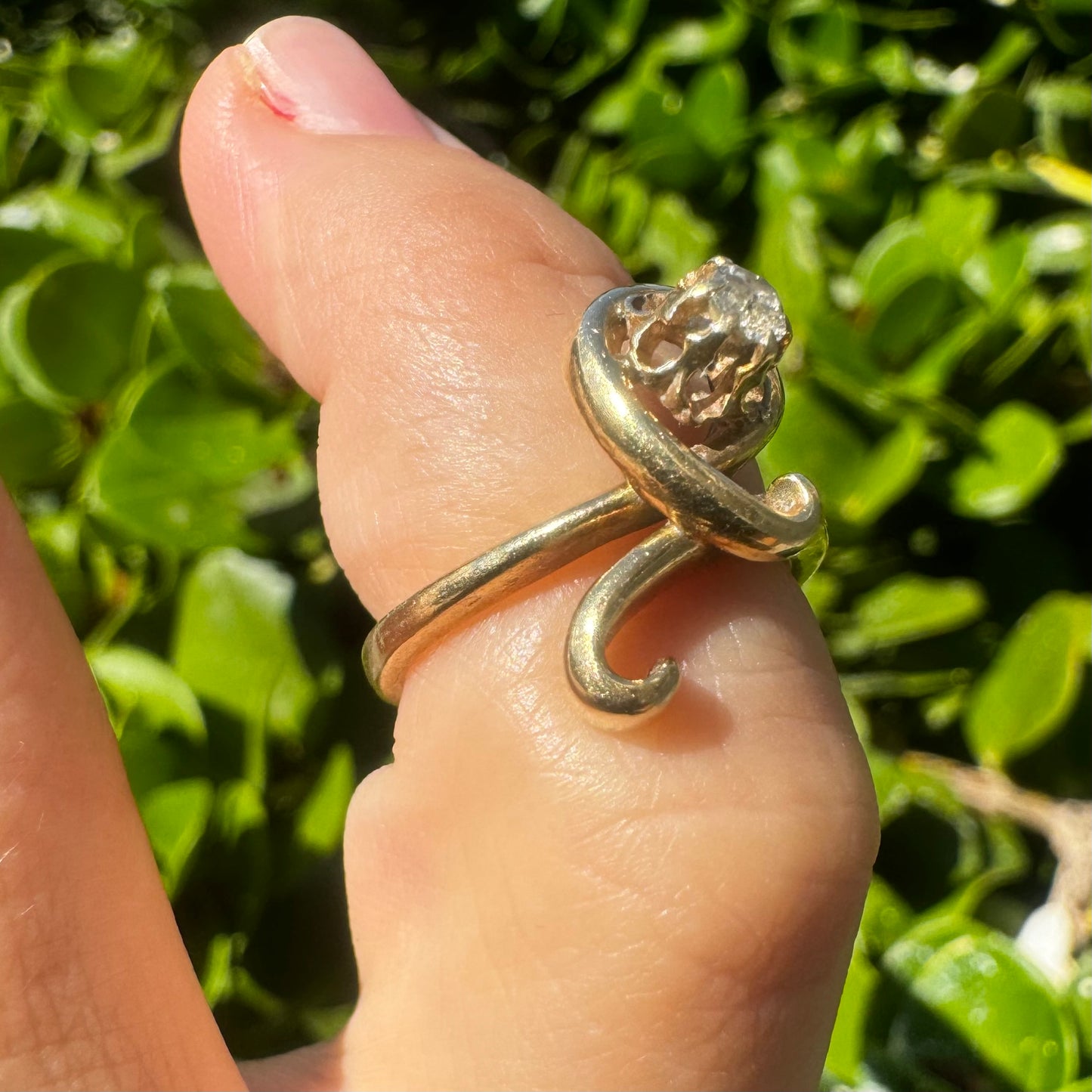 טבעת זהב צהוב 14 קראט משובצת יהלום מרכזי בעיצוב פיסולי וזורם.