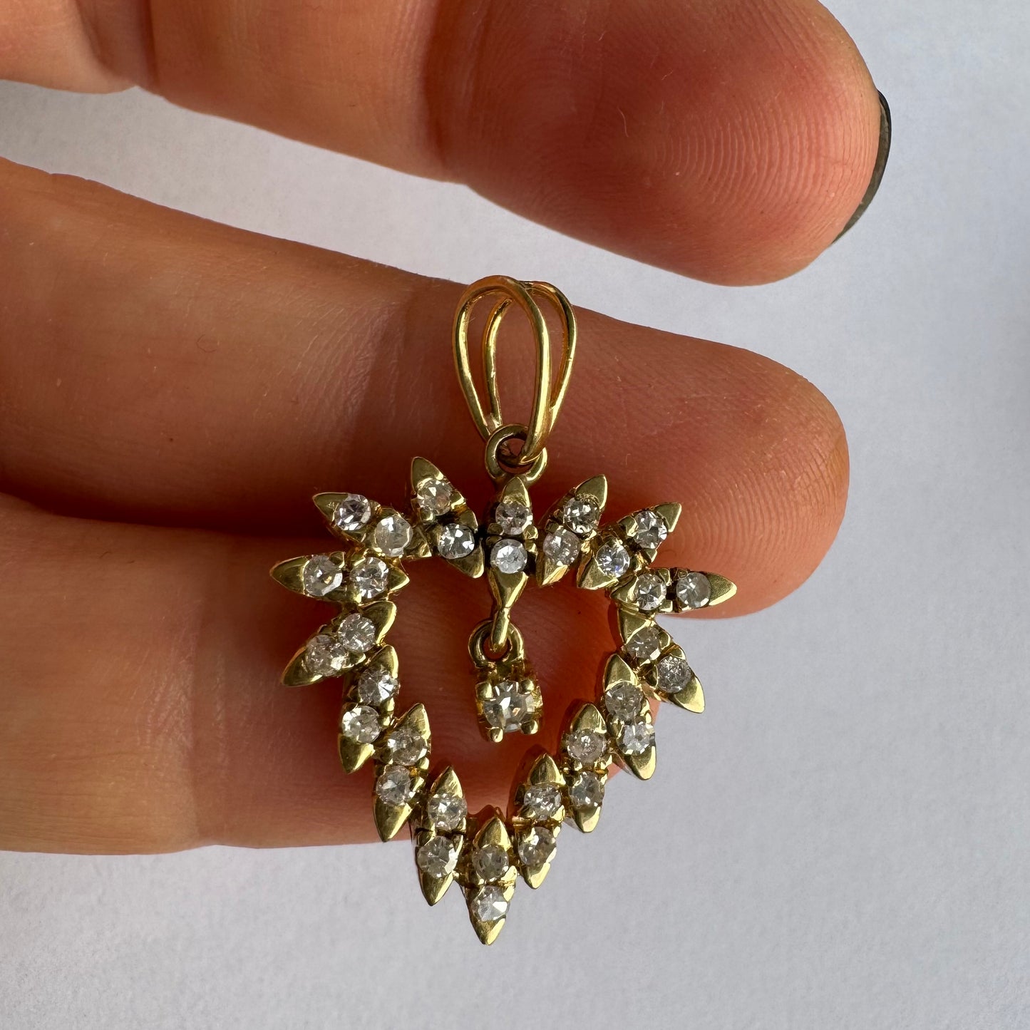 תליון זהב צהוב 14 קראט בצורת לב, משובץ יהלומים בסידור עדין היוצר מראה עשיר ומלא ברק.