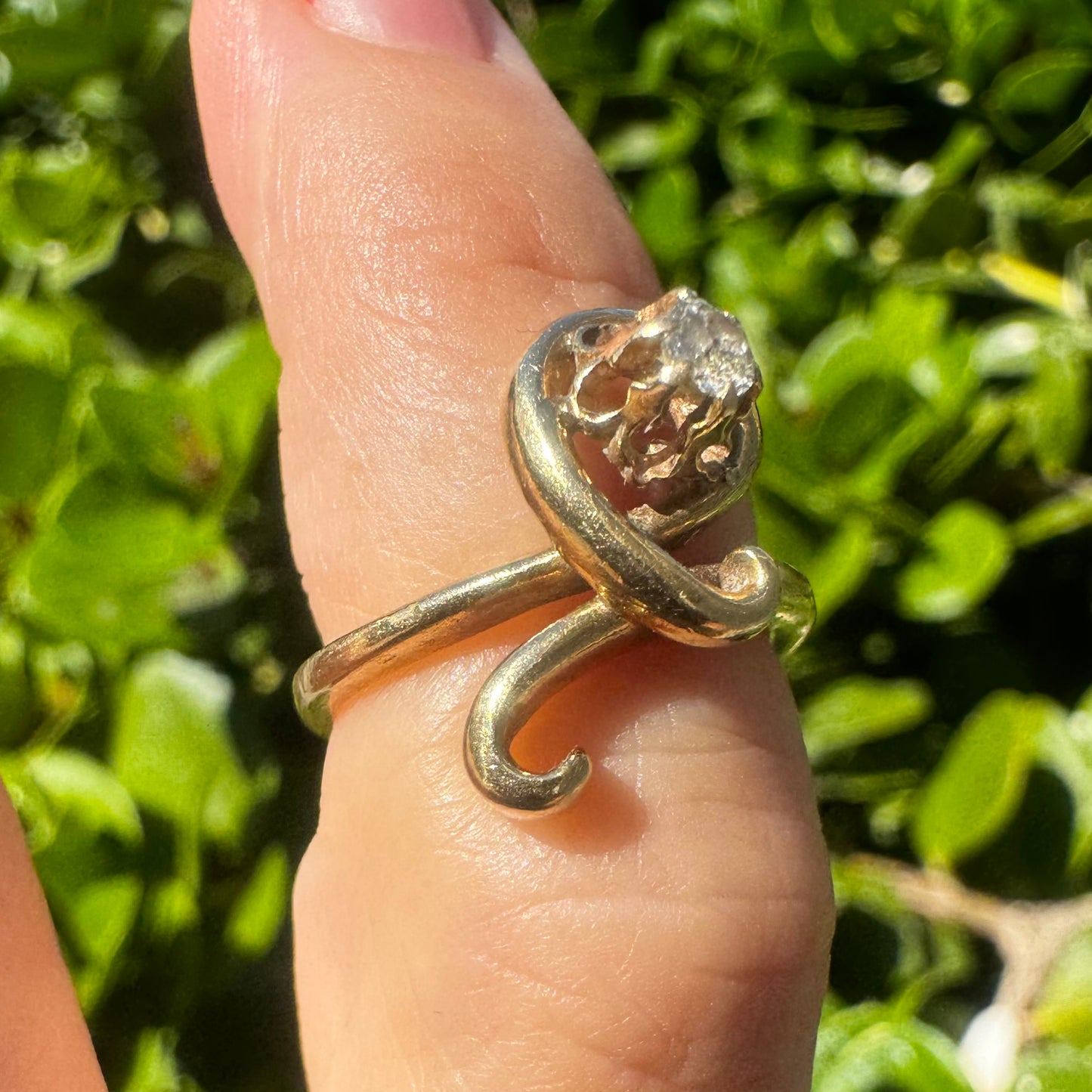 טבעת זהב צהוב 14 קראט משובצת יהלום מרכזי בעיצוב פיסולי וזורם.