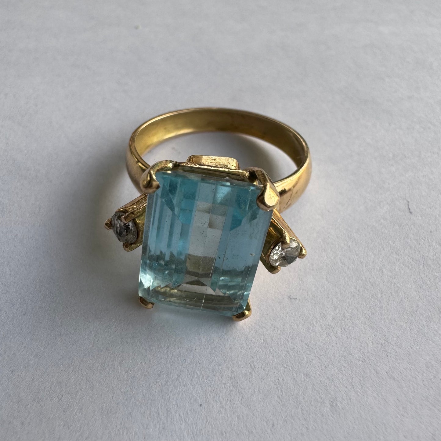 טבעת זהב 18 קראט משובצת אבן אקוומרין בחיתוך מלבני (Emerald Cut), בעלת גוון כחול צלול ומרשים.