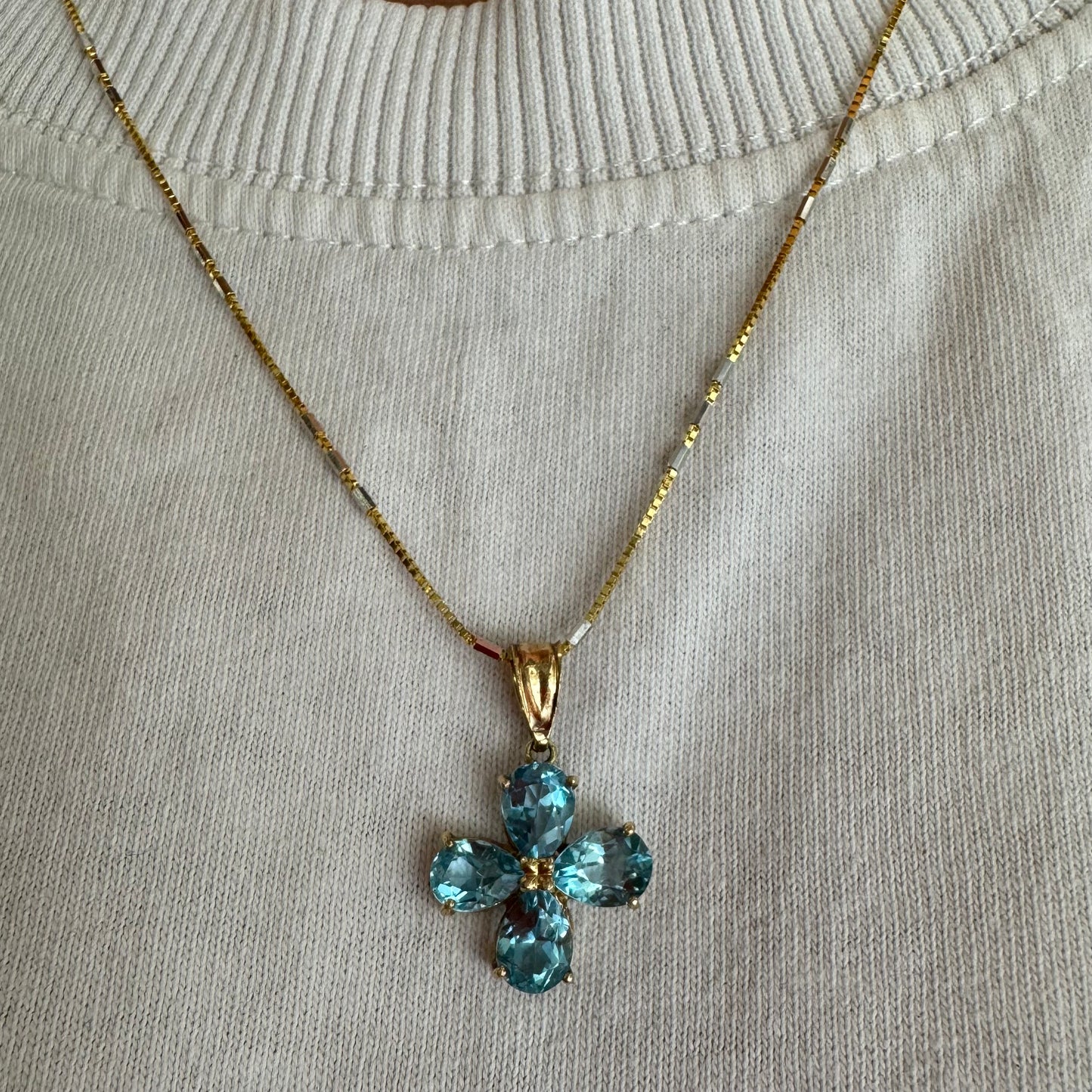 14K gold necklace with a cheerful floral pendant crafted from four pear-shaped Blue Topaz gemstones, arranged in a radiant blossom design