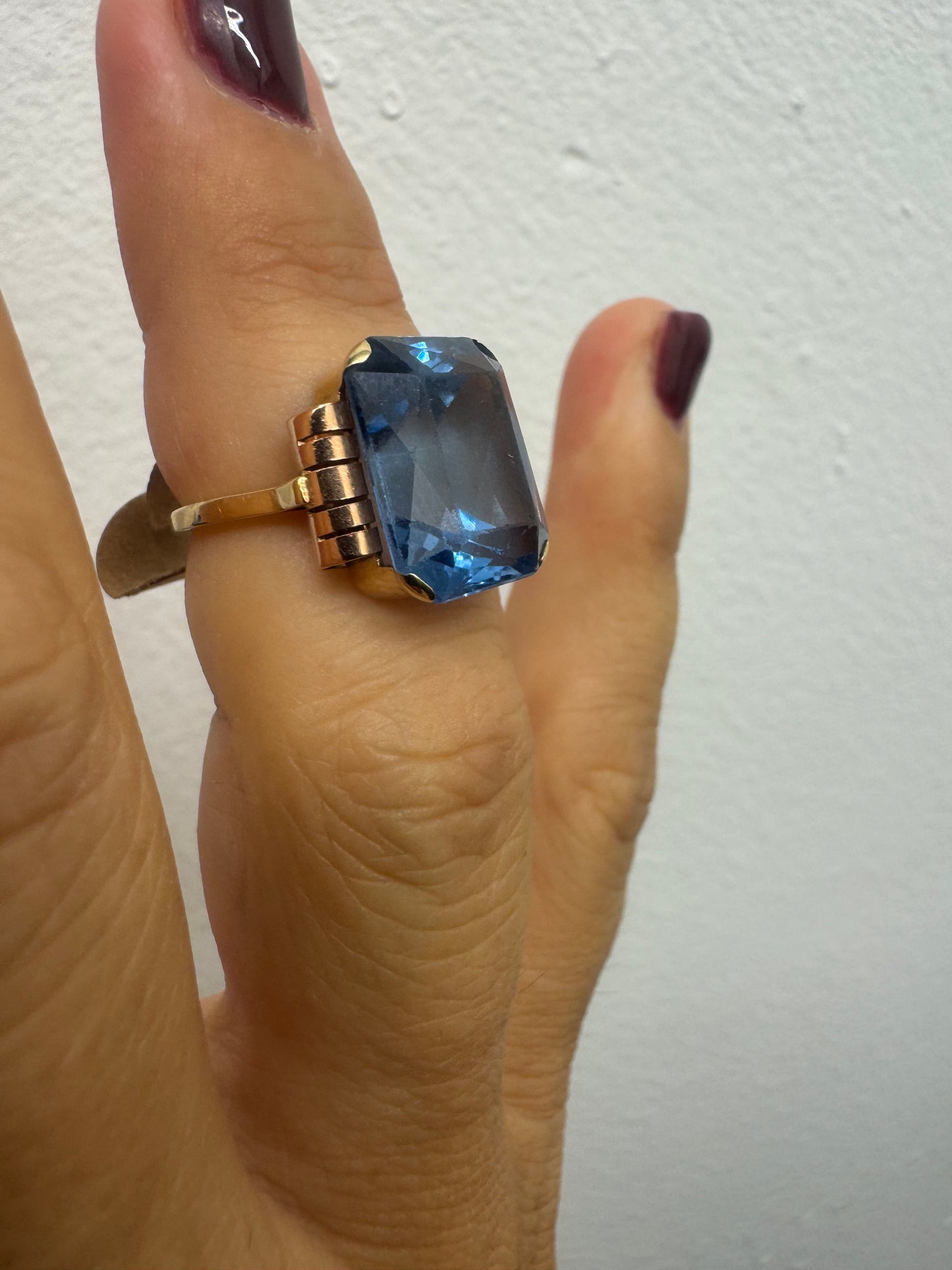 18K gold ring featuring a large rectangular Blue Topaz in a bezel setting with decorative side details.