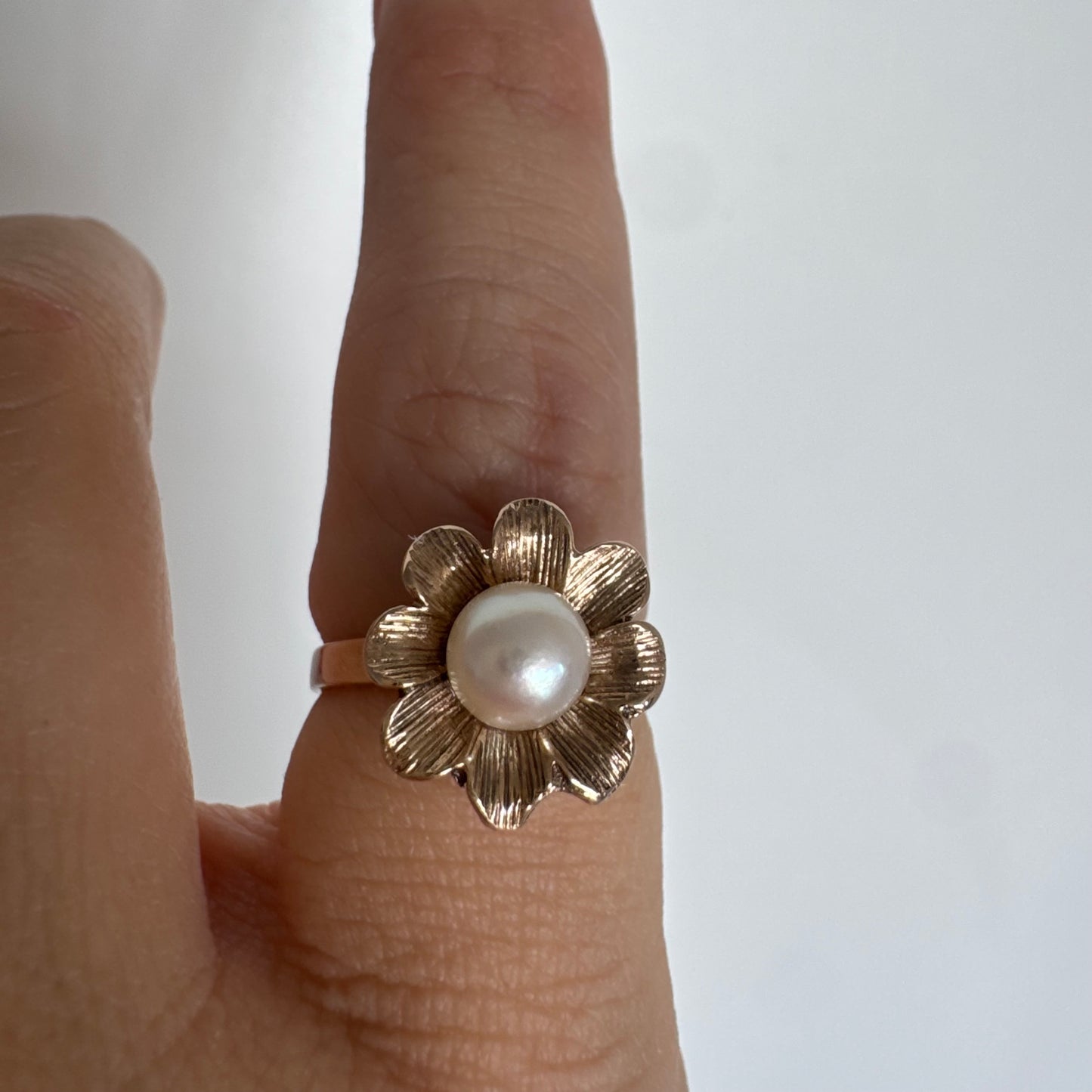 9K gold flower ring set with a lustrous Pearl at the center.