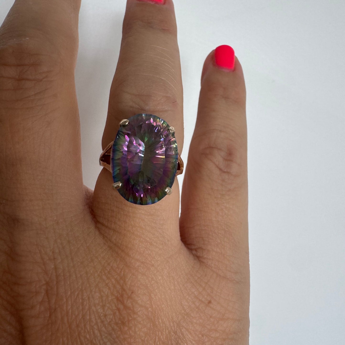 9K gold ring set with a large iridescent stone displaying mesmerizing shades of purple, green, and blue that shift beautifully in the light.
