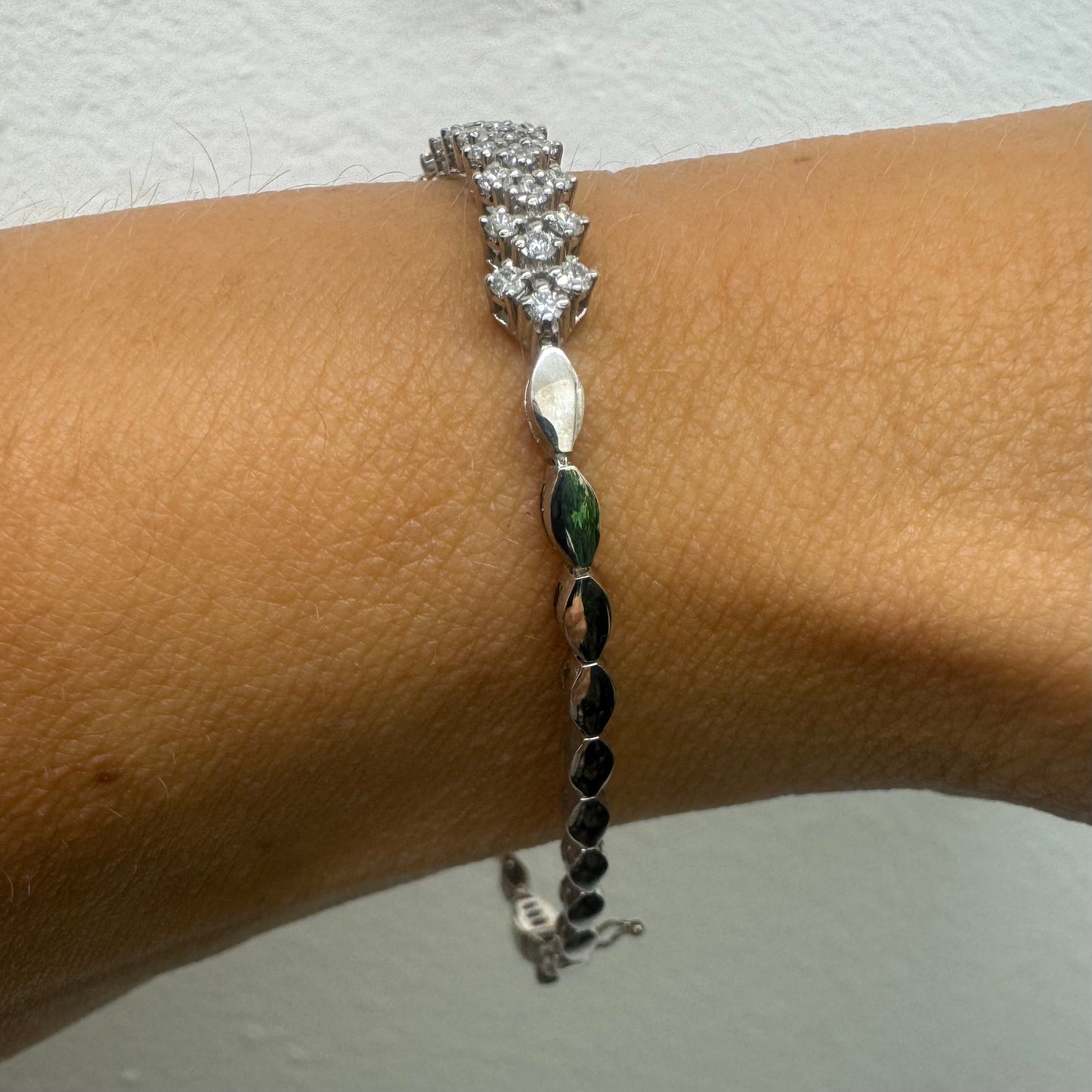 14K white gold bracelet set with sparkling white Diamonds in an elegant floral pattern.