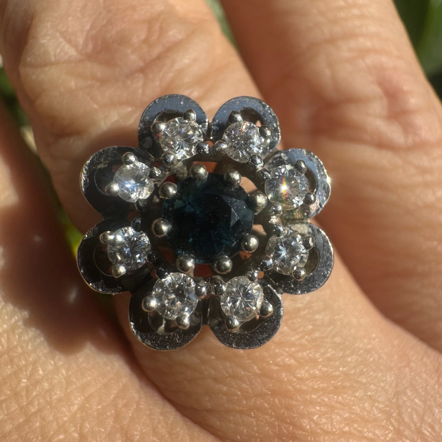 14K gold floral ring set with a round deep blue Sapphire at its center & Diamonds