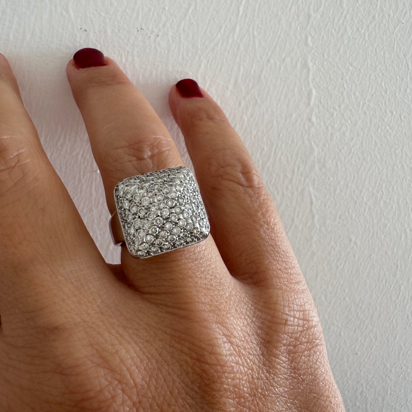 טבעת זהב לבן 18 קראט עם חלק עליון רחב בצורת ריבוע המשובץ כולו ביהלומים מנצנצים, ליצירת מראה יוקרתי ונוצץ.