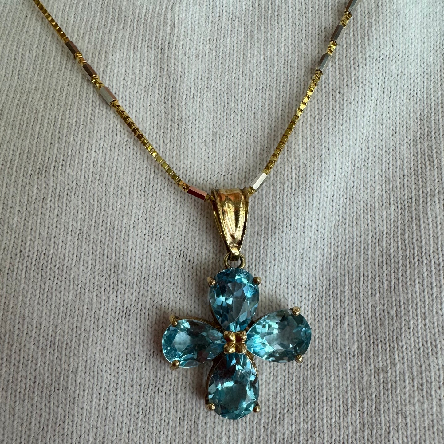 14K gold necklace with a cheerful floral pendant crafted from four pear-shaped Blue Topaz gemstones, arranged in a radiant blossom design