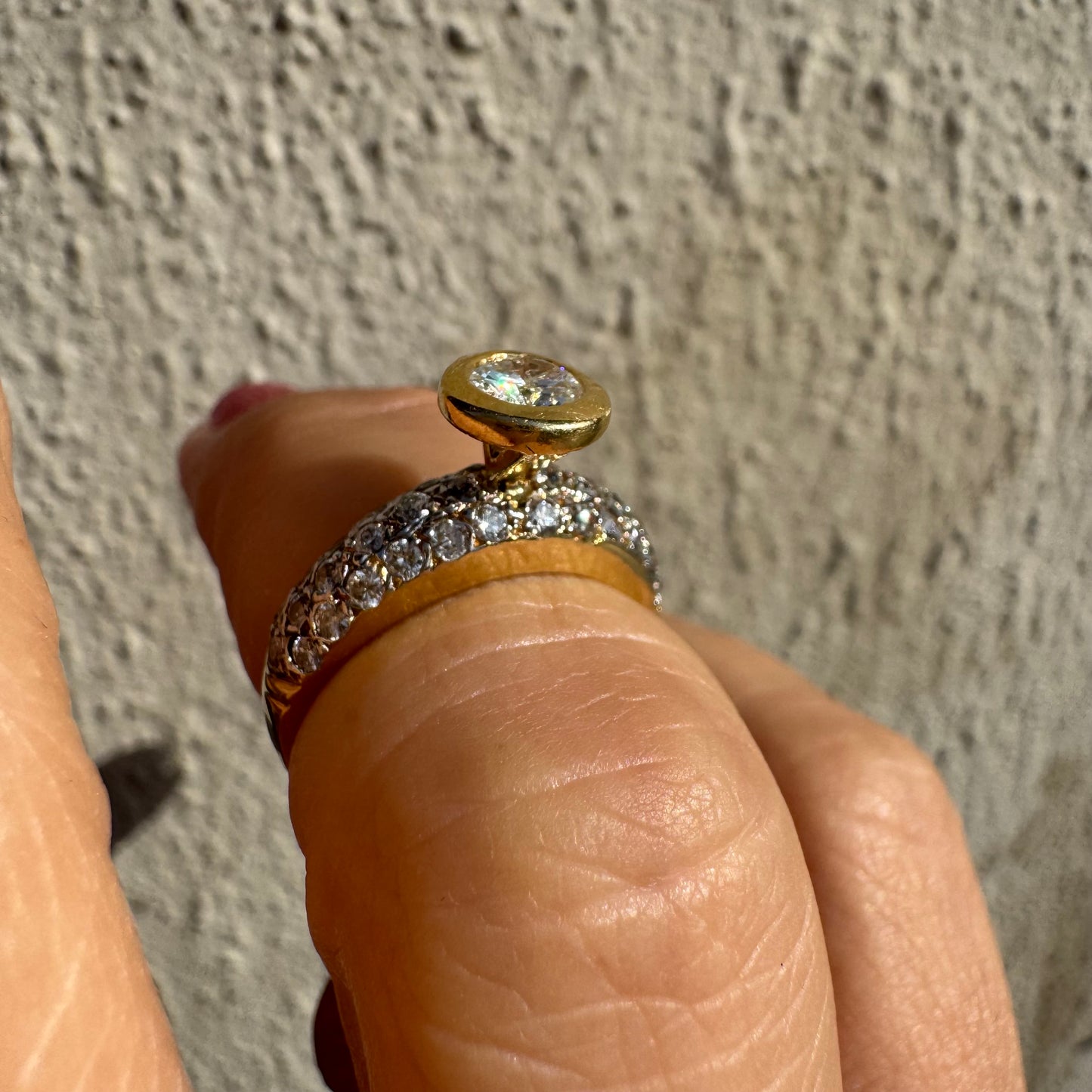 טבעת זהב צהוב 14 קראט משובצת יהלום עגול ויהלומים נוספים על הרצועה.