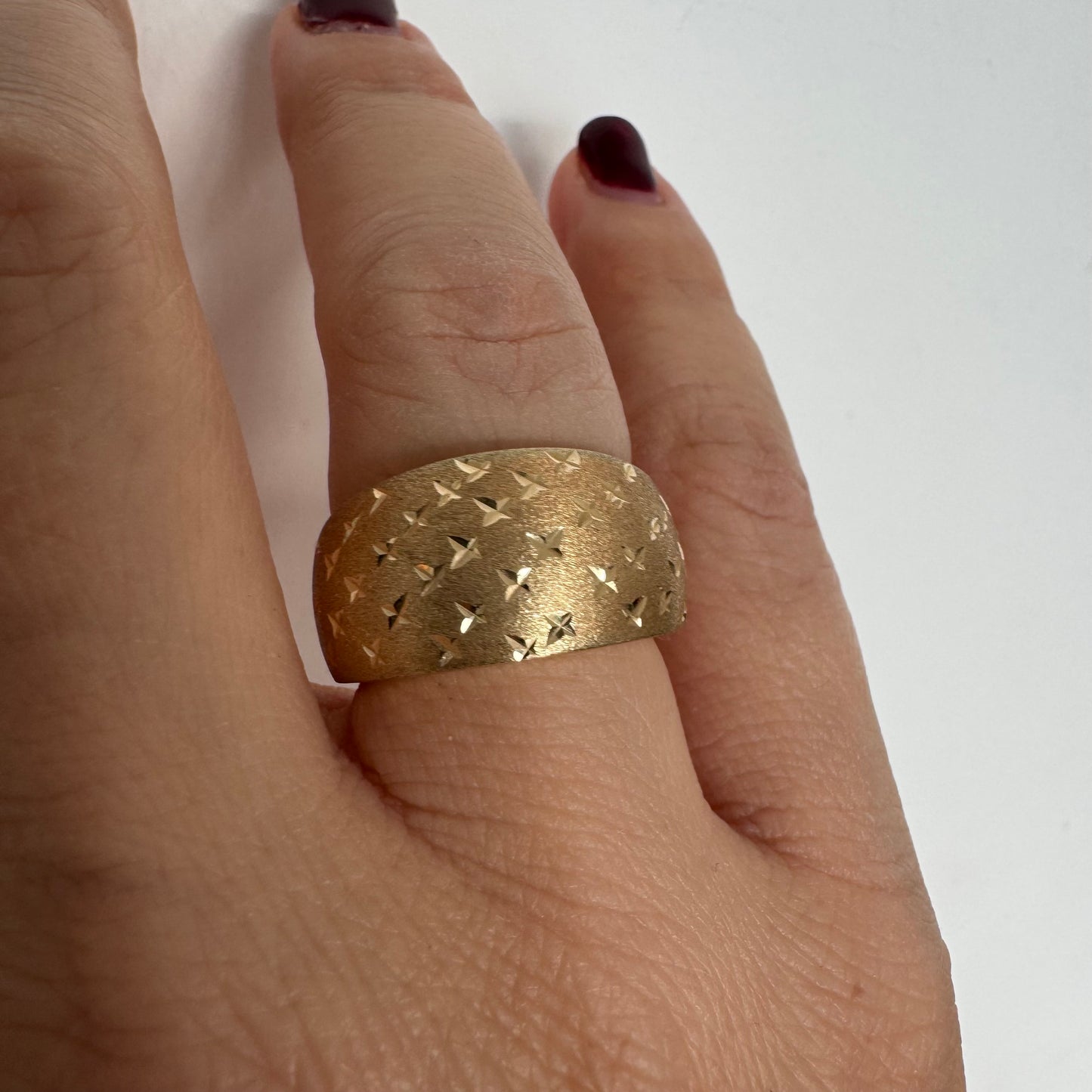 14K gold wide signet-style ring with a matte finish and delicate star engravings.