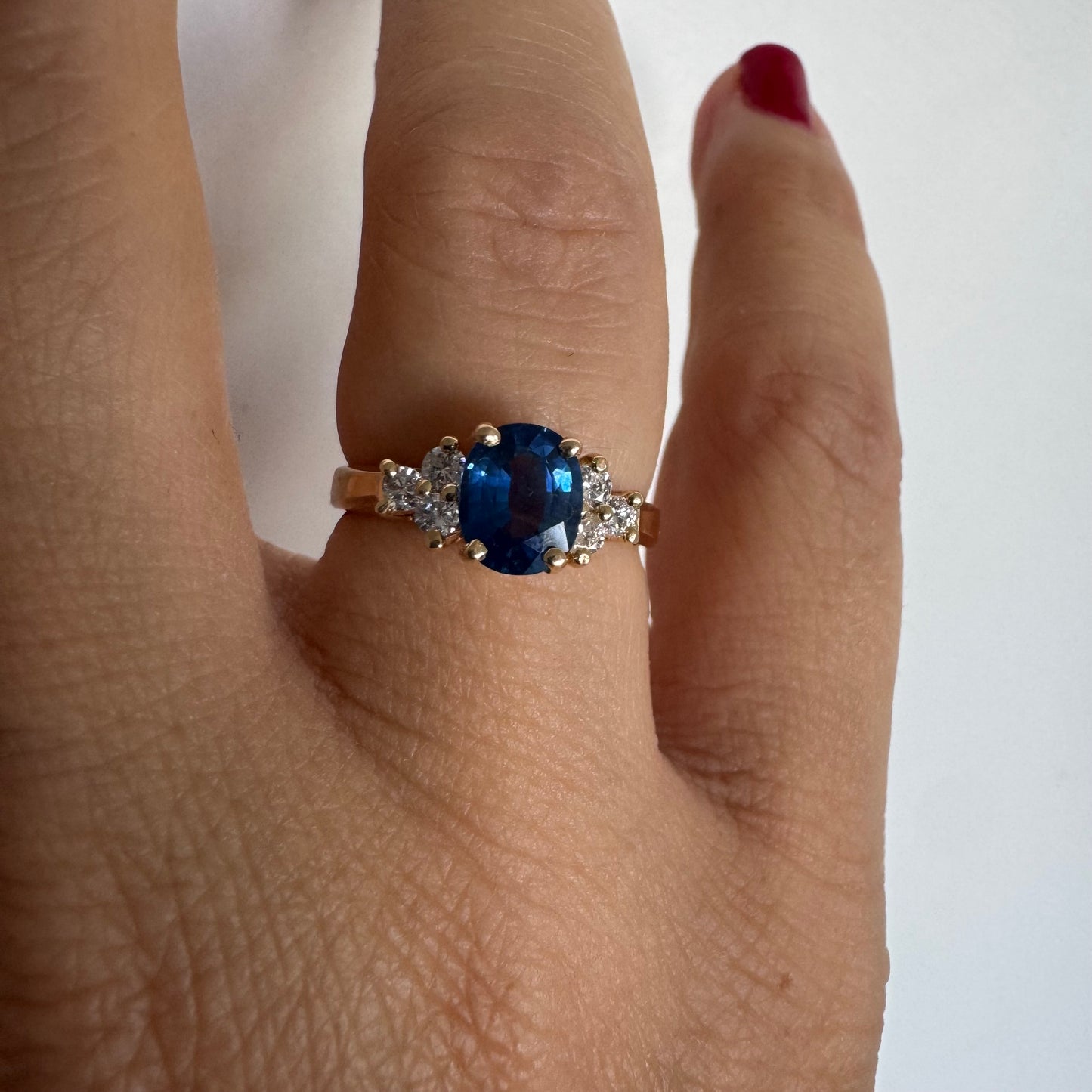14K gold ring set with an oval blue Sapphire at the center & Diamonds