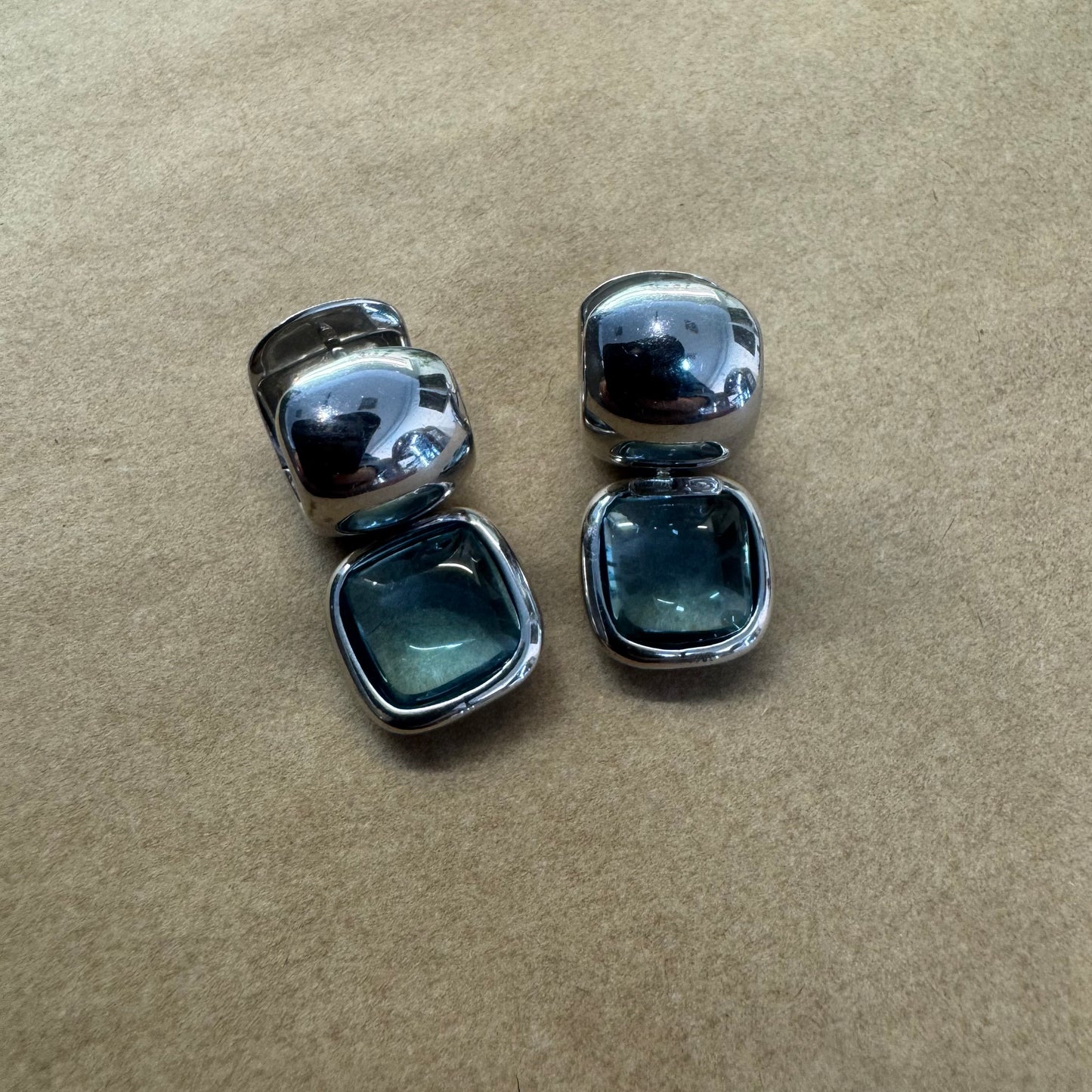 18K gold drop earrings featuring cushion-shaped Aquamarine in a smooth bezel setting, with a polished, modern design.