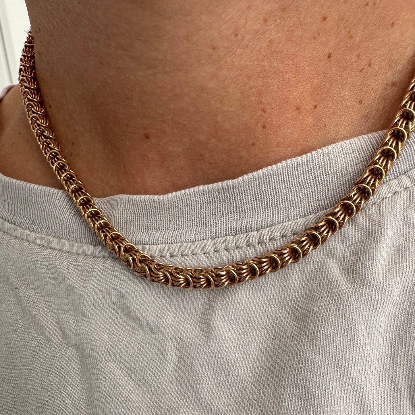 14K gold necklace featuring intricate, interwoven links that create a rich and textured look.