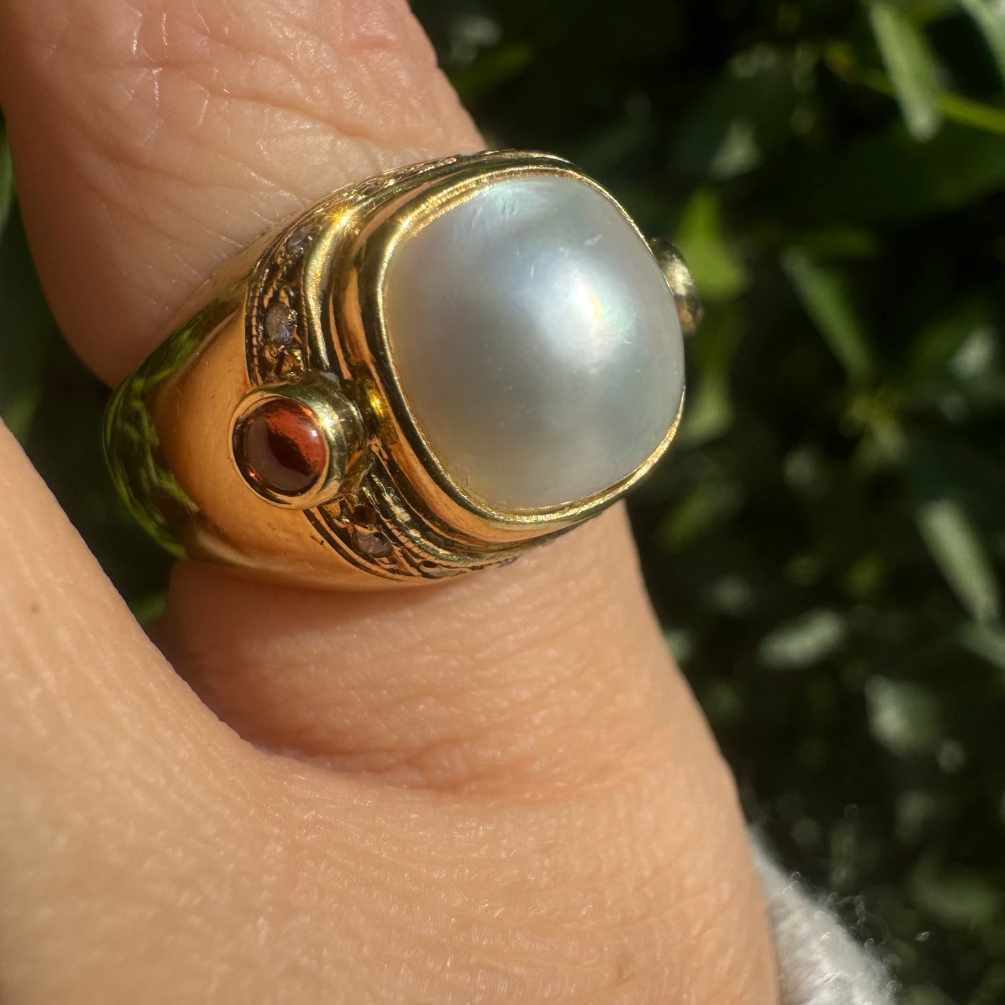 18K gold ring set with a luminous baroque Pearl, flanked by deep red Tourmaline cabochons & Diamonds