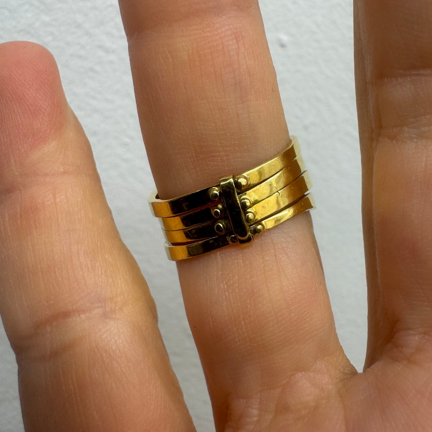 טבעת זהב צהוב 18 קראט, משובצת בשורות צבעוניות של ספירים, אמרלדים, רובינים ויהלומים – פריט אלגנטי מלא חיים וזוהר.