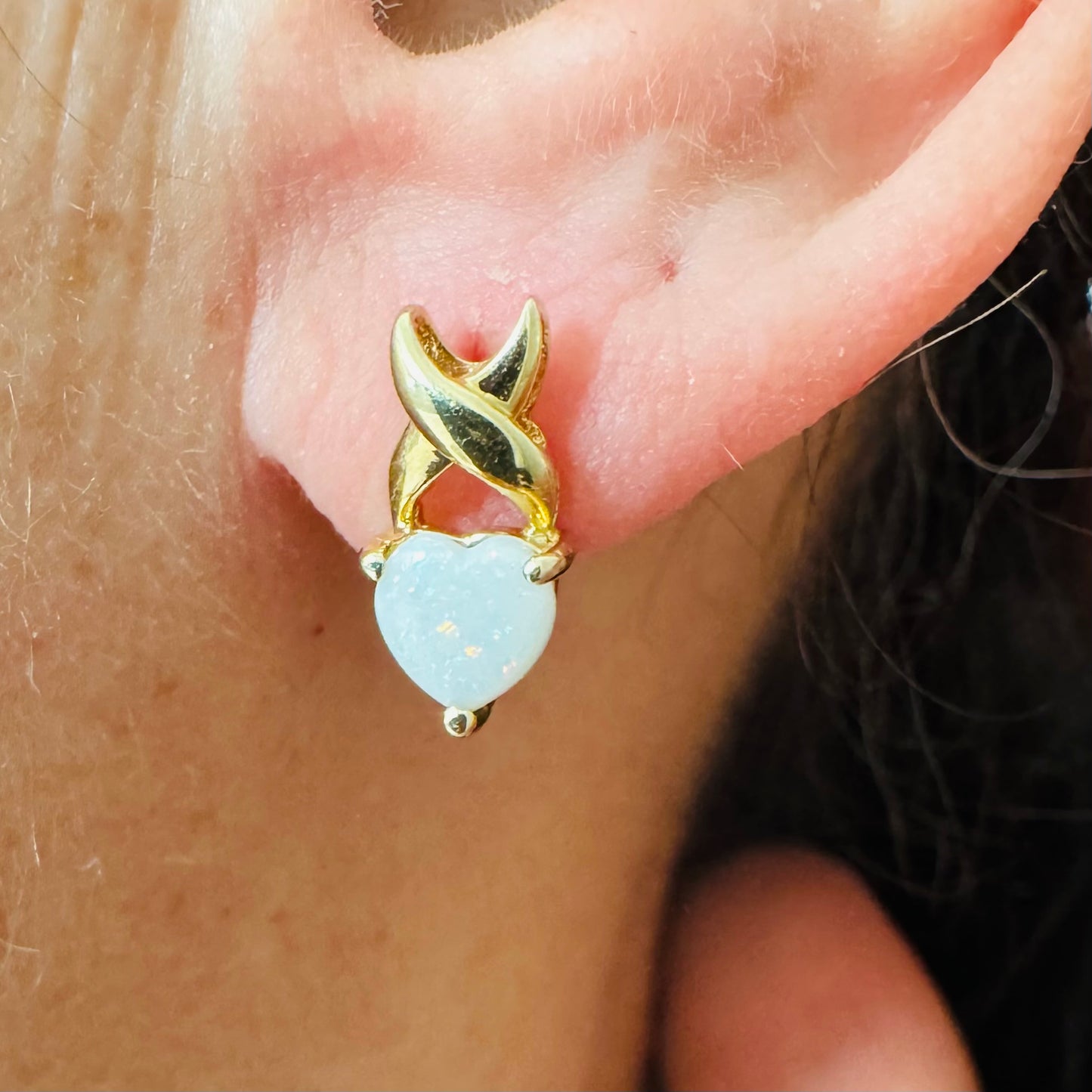 עגילי זהב צהוב 14 קראט משובצים אבני אופל בחיתוך לב, עם משחקי צבע טבעיים בגווני ירוק, ורוד וזהב.