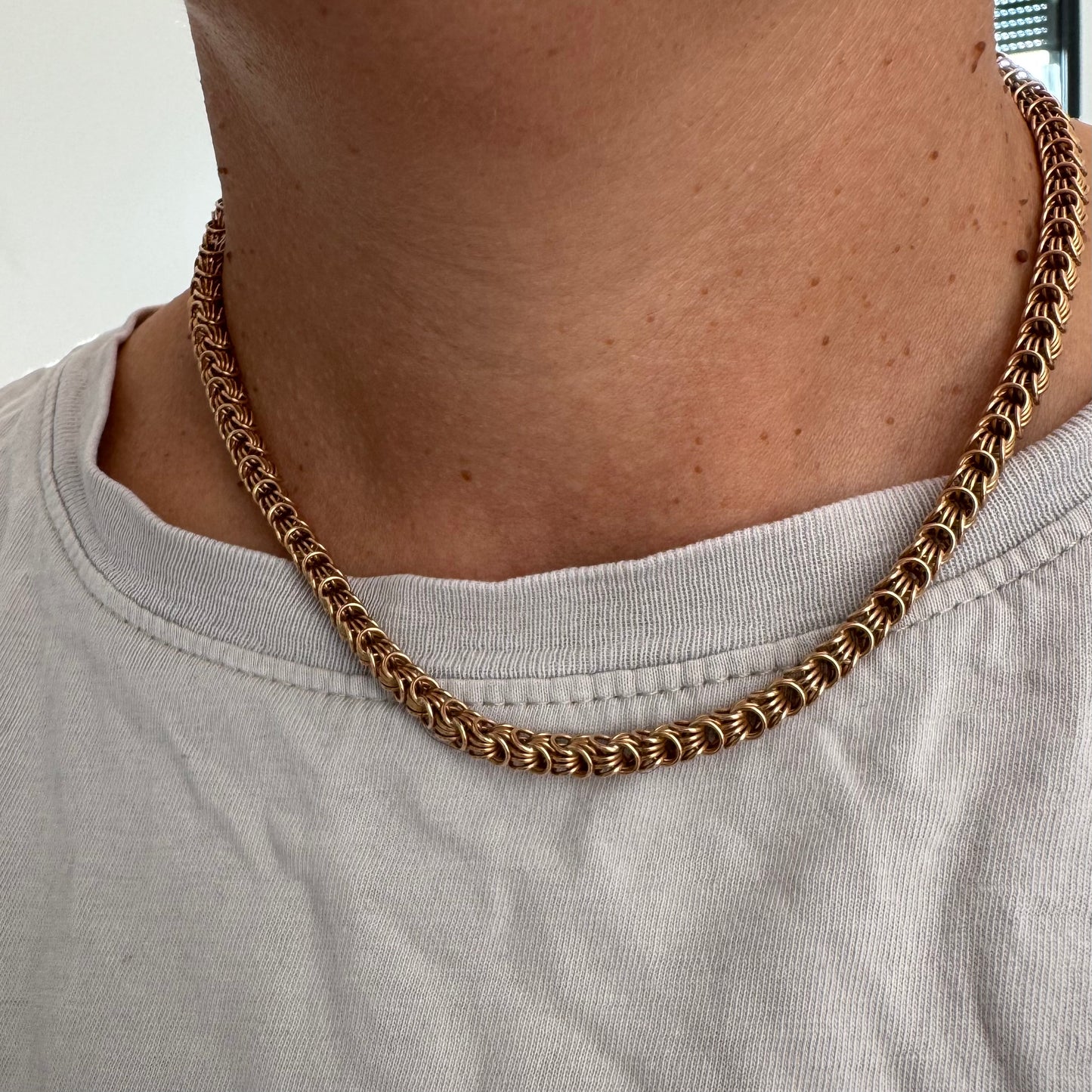 14K gold necklace featuring intricate, interwoven links that create a rich and textured look.