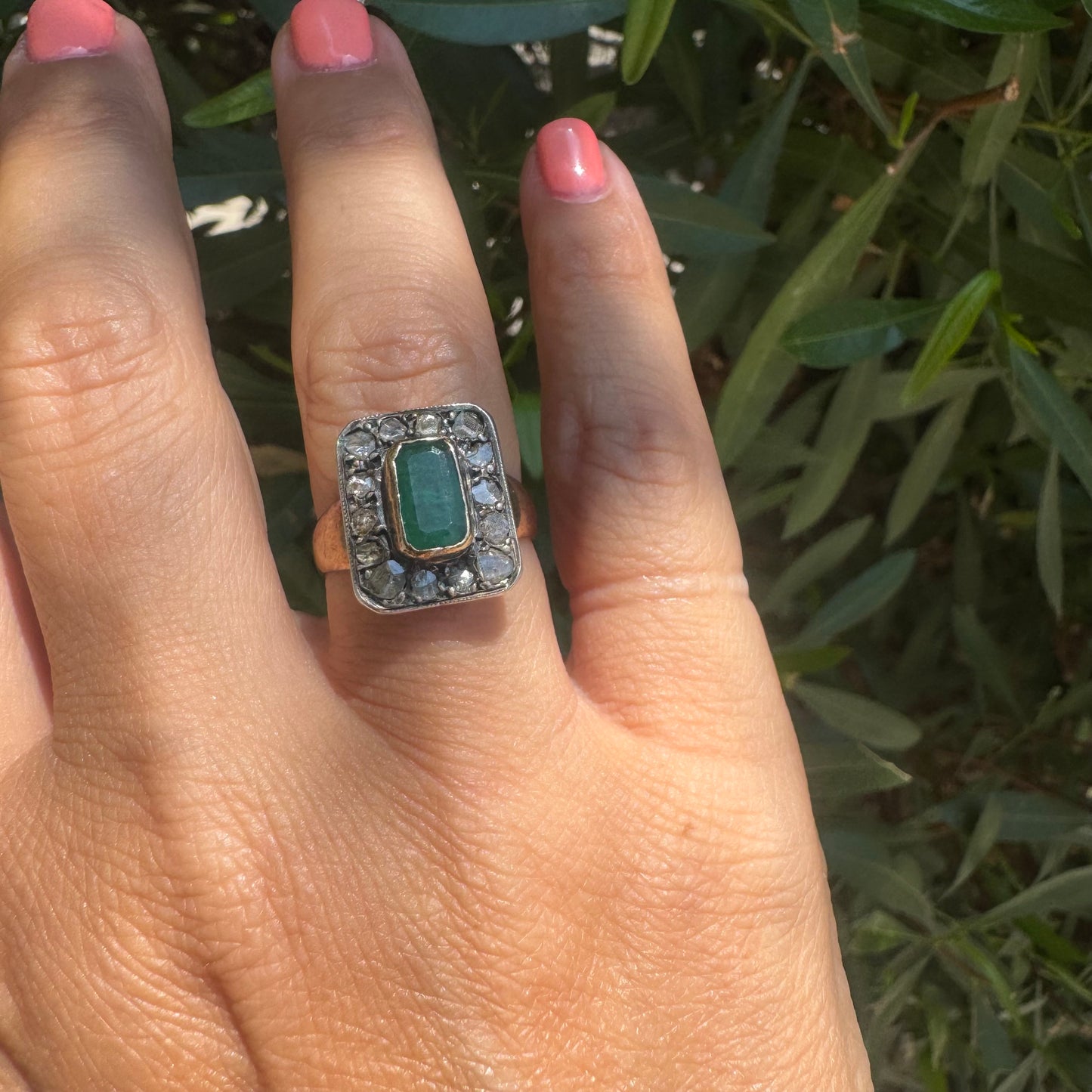 18K gold ring set with a rectangular Emerald and framed by a halo of rose-cut Diamonds