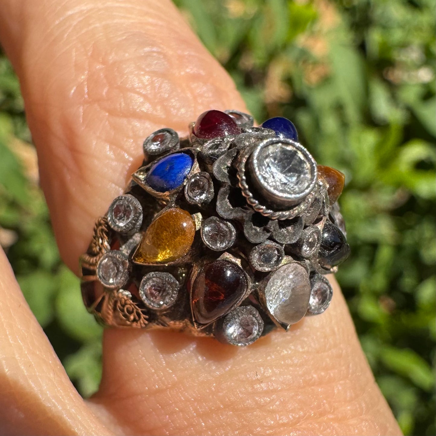 14K gold ring set with a central transparent gemstone surrounded by a vibrant mosaic of colorful gemstones -set in an ornate, handcrafted design