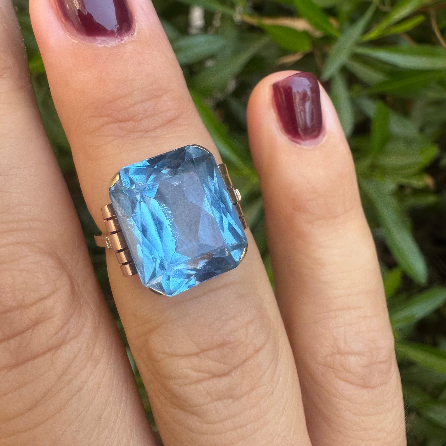 18K gold ring featuring a large rectangular Blue Topaz in a bezel setting with decorative side details.