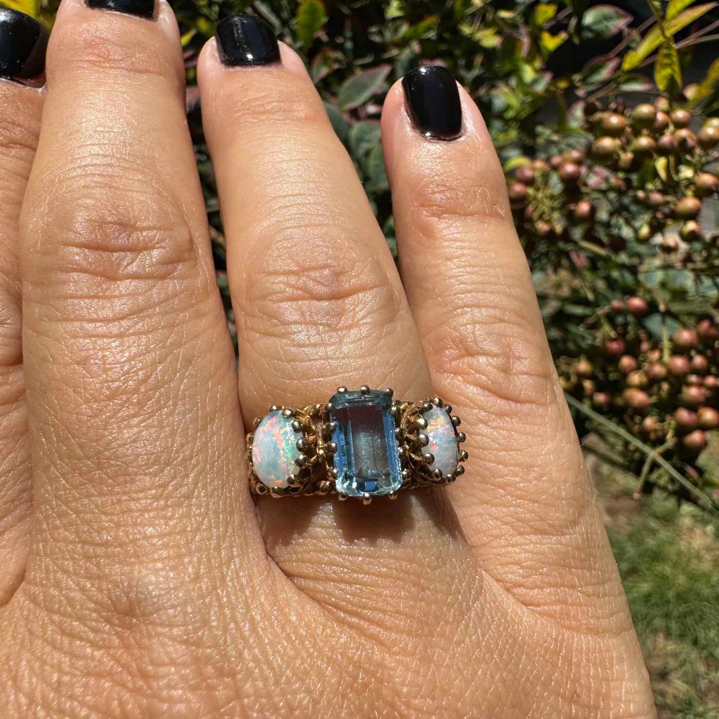 10K gold ring set with a light blue Aquamarine flanked by two dreamy Opals