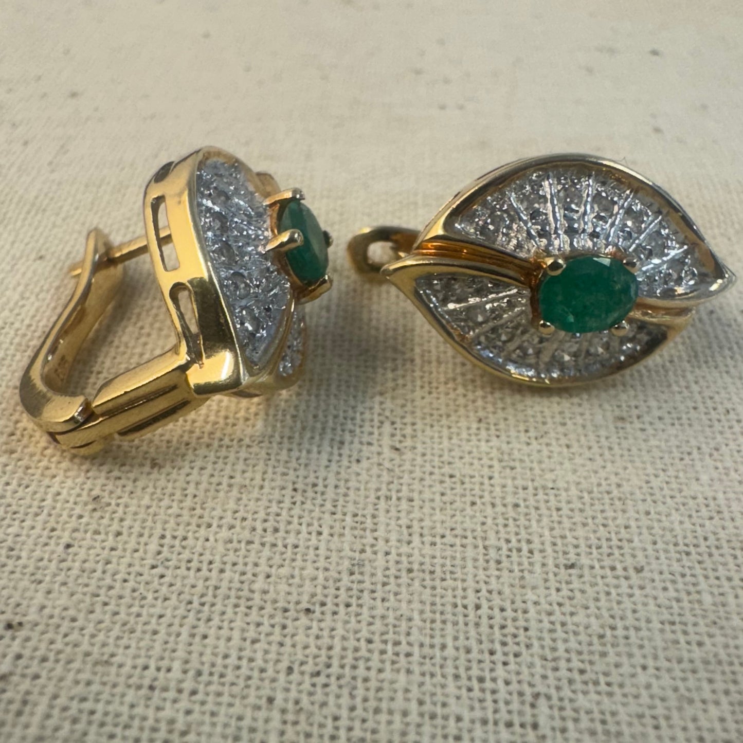 14K gold drop earrings in a refined leaf design, set with vivid green Emeralds at the center and shimmering pavé-set Diamonds along the curves