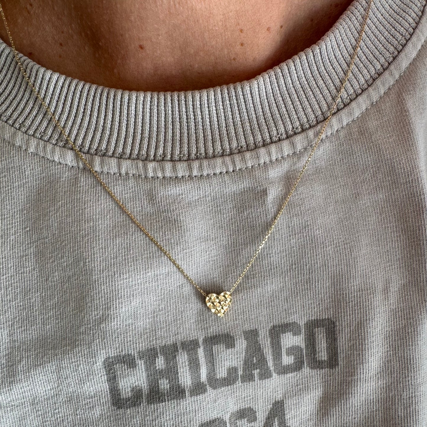 14K gold necklace featuring a heart-shaped pendant with a delicate geometric texture