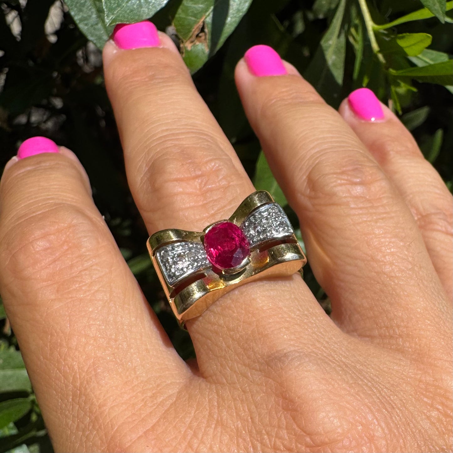 18K gold ring in a sculptural bow-inspired design.
Set with a vivid oval-cut Ruby at the center, framed by shimmering Diamonds