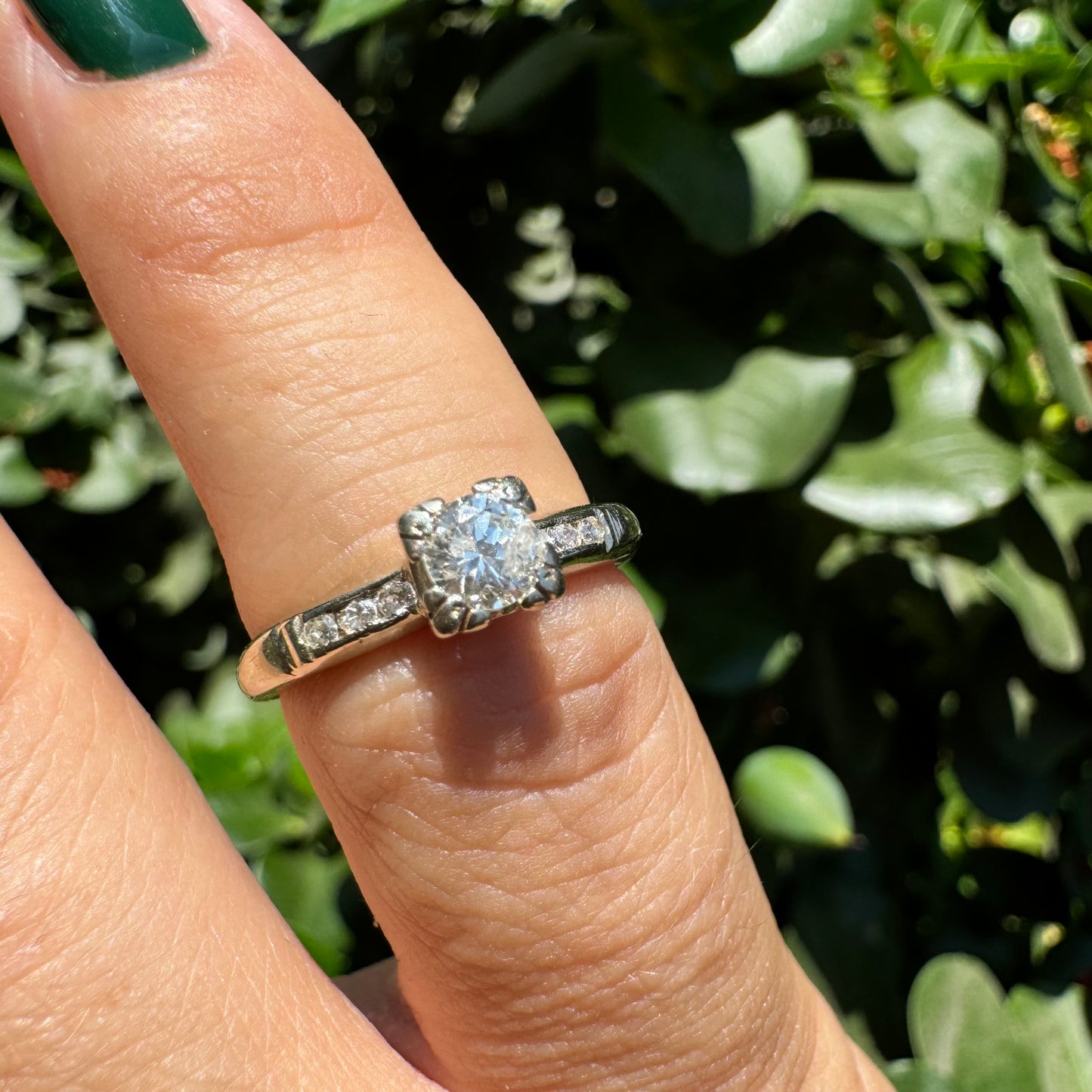 טבעת זהב לבן 14 קראט משובצת יהלום מרכזי ויהלומים בצדדים