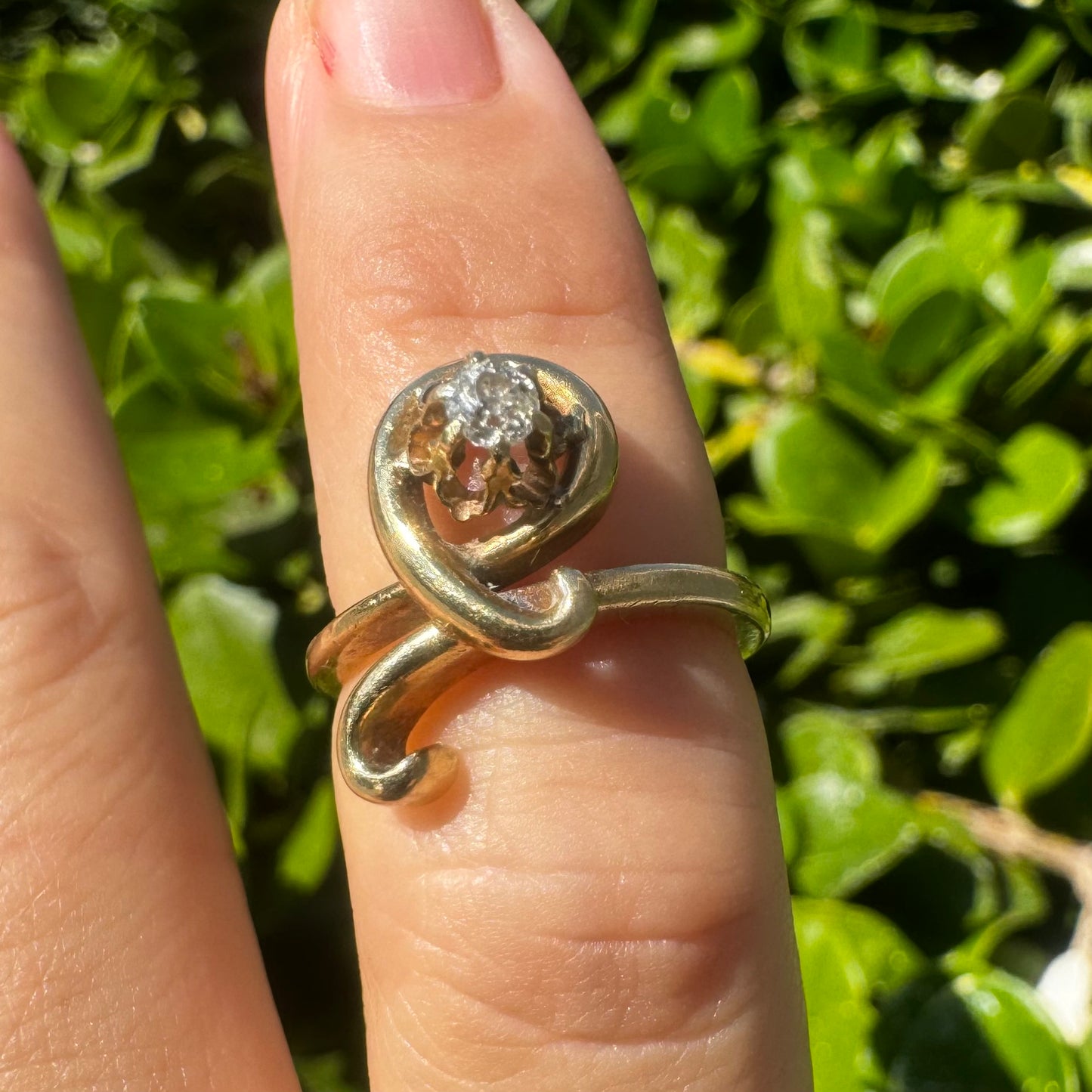 טבעת זהב צהוב 14 קראט משובצת יהלום מרכזי בעיצוב פיסולי וזורם.