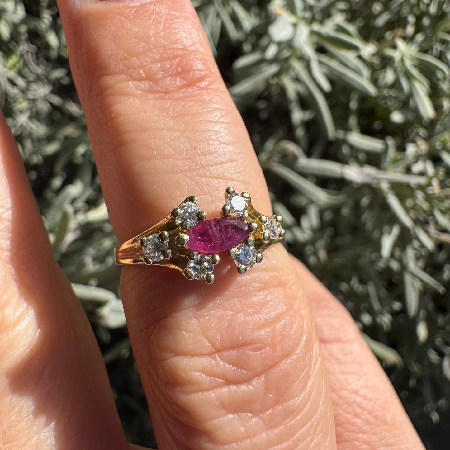 18K gold ring set with a marquise-cut Ruby accented by round Diamonds on each side.