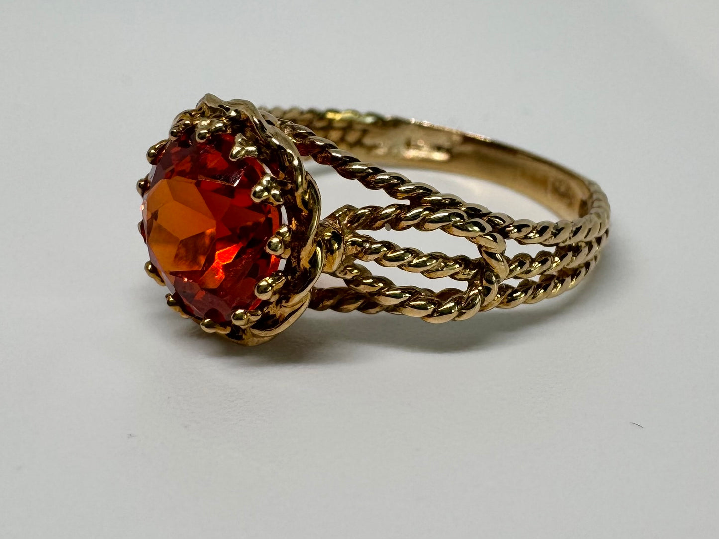 10K gold ring set with a vivid orange gemstone