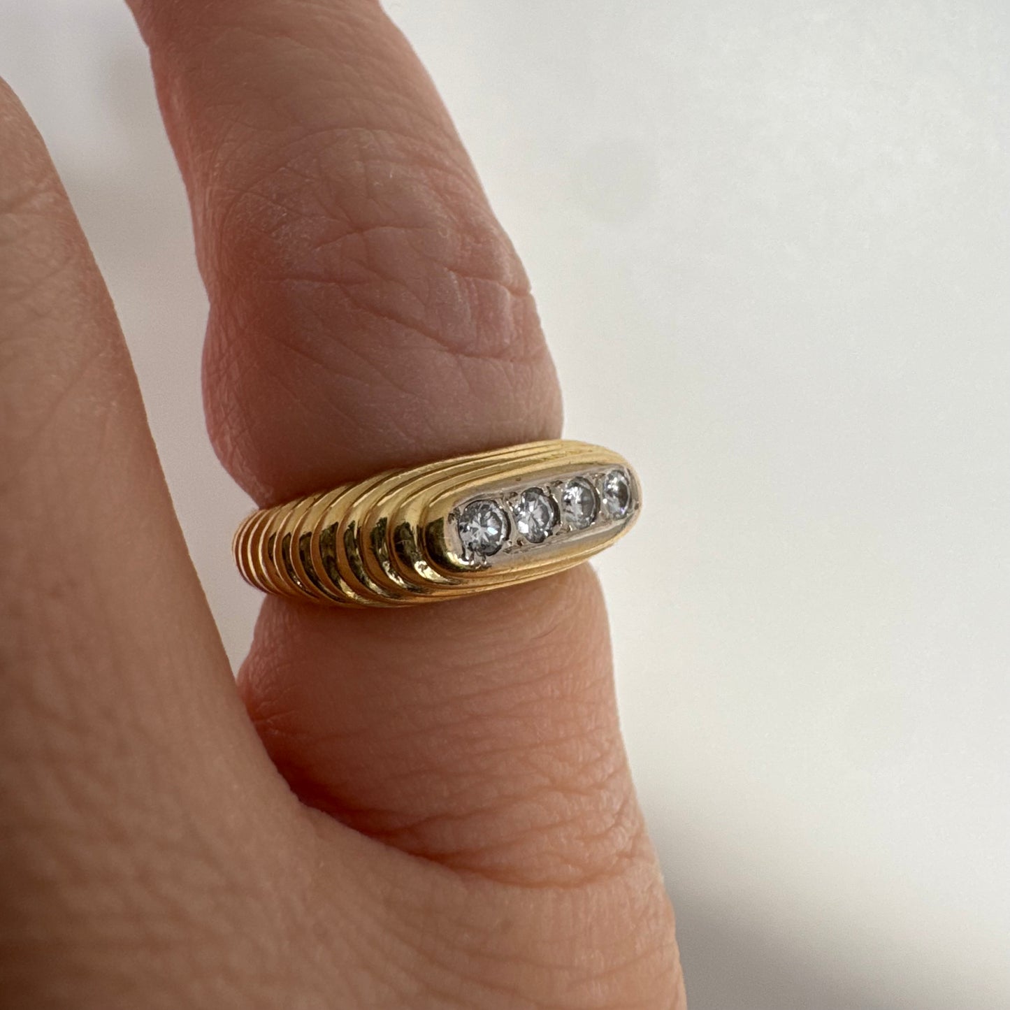 14K gold elongated oval ring set with five round Diamonds in a channel setting.