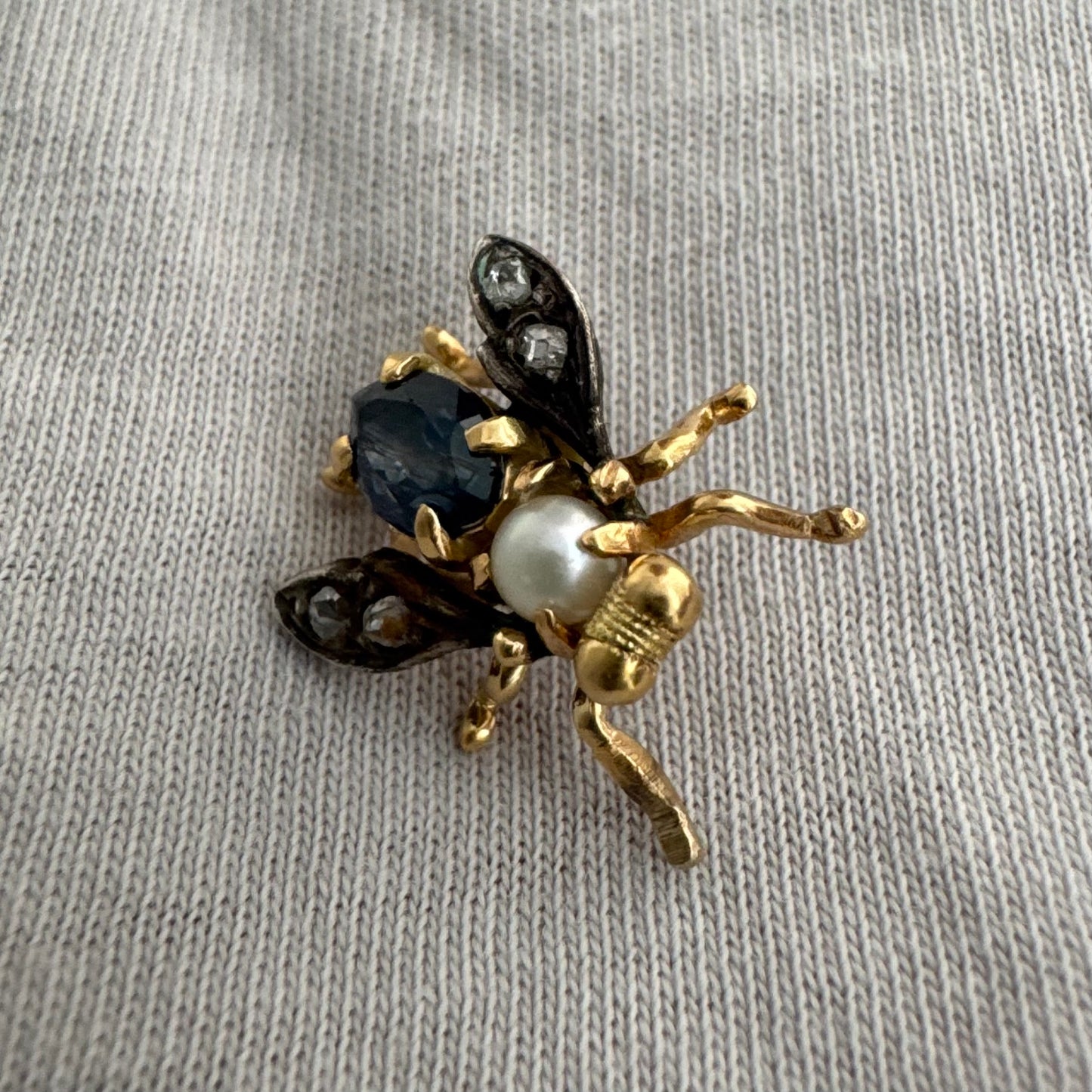 14K gold insect stick pin set with sapphire, seed pearl, and small diamonds.