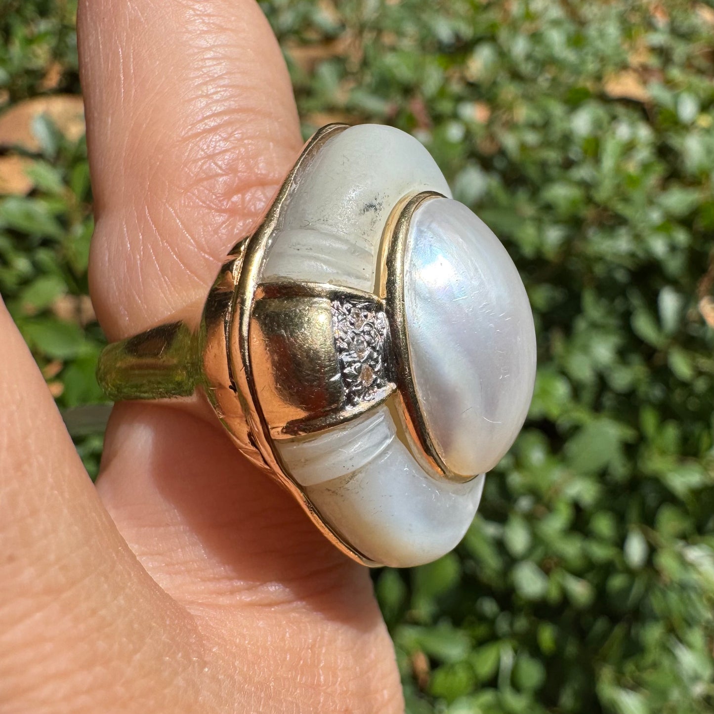 טבעת זהב צהוב 14 קראט משובצת באבן אם הפנינה טבעית במראה זוהר, עם שיבוץ יהלומים עדין בצדדים.