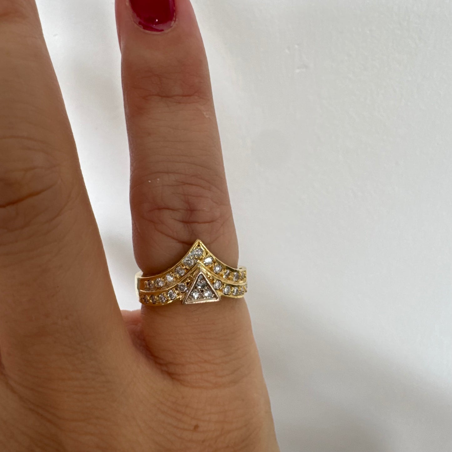 טבעת זהב צהוב 18 קראט בעיצוב גאומטרי ייחודי, משובצת יהלומים נוצצים בחיתוך עגול.