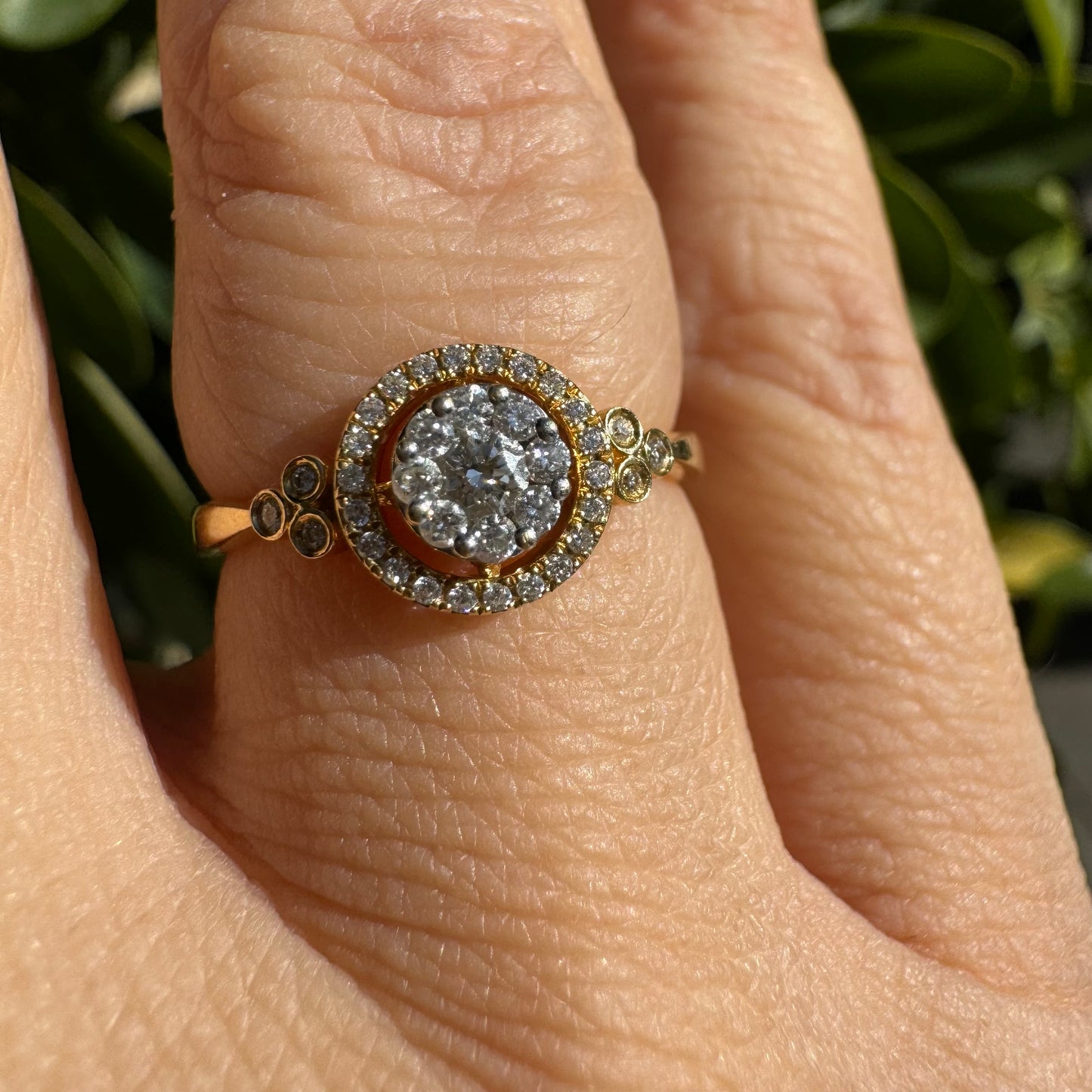 טבעת זהב צהוב 14 קראט משובצת אשכול עגול של יהלומים במרכז, מוקף בהילה של יהלומים קטנים ונוצצים