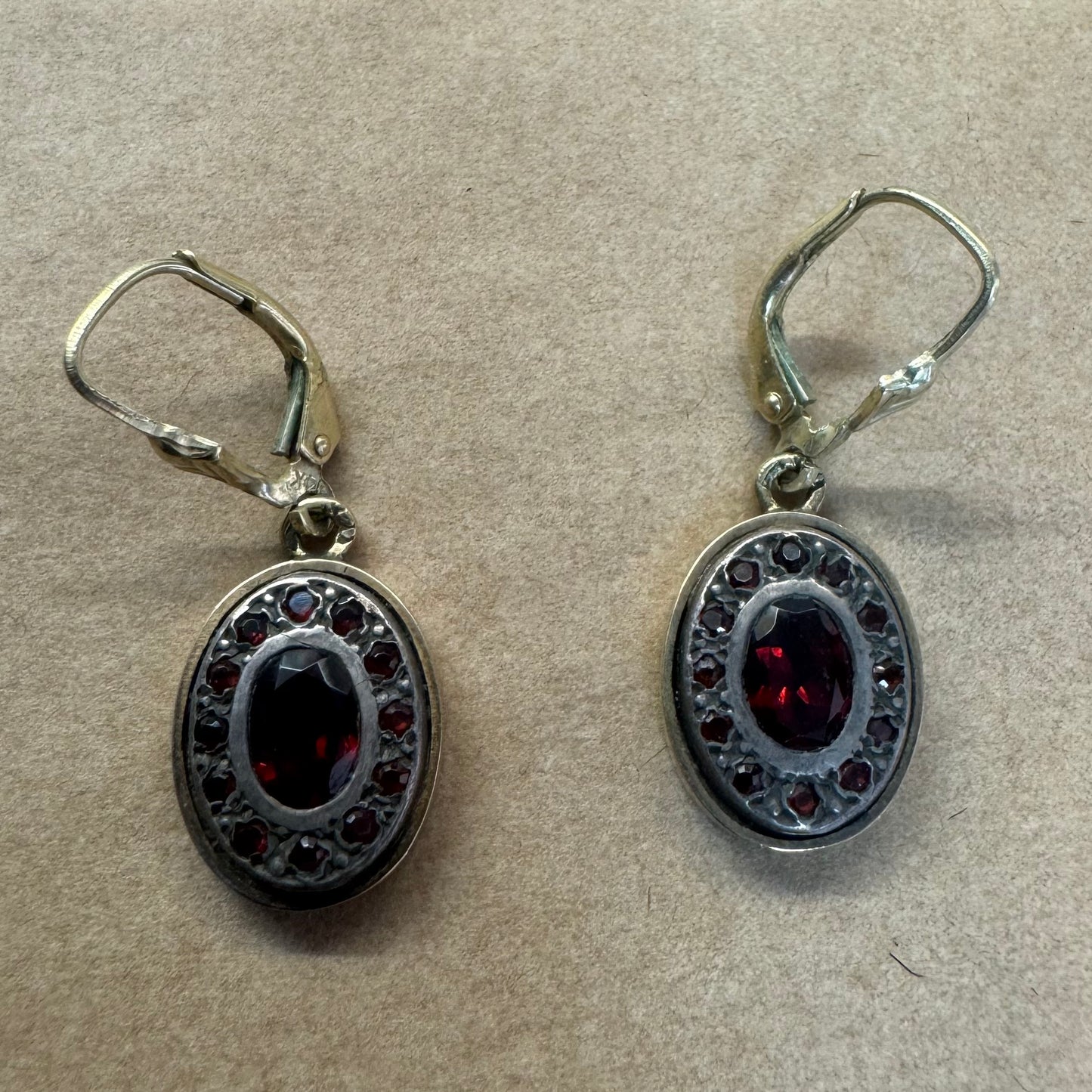 14K gold drop earrings set with deep red oval Garnets surrounded by smaller stones Garnets.