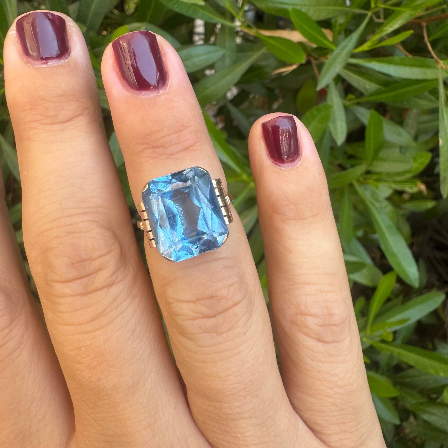 18K gold ring featuring a large rectangular Blue Topaz in a bezel setting with decorative side details.