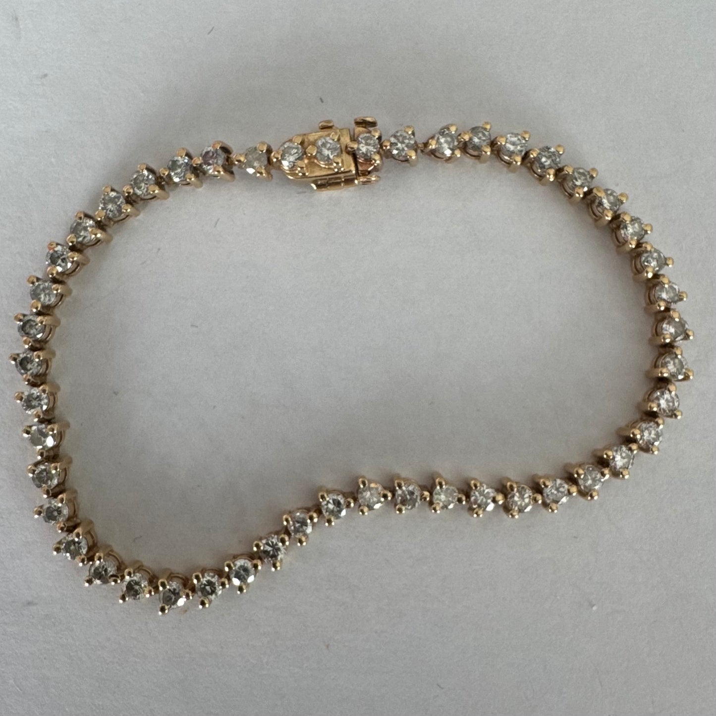 14K gold tennis bracelet set with a continuous line of round Diamonds, creating a delicate and elegant sparkle.