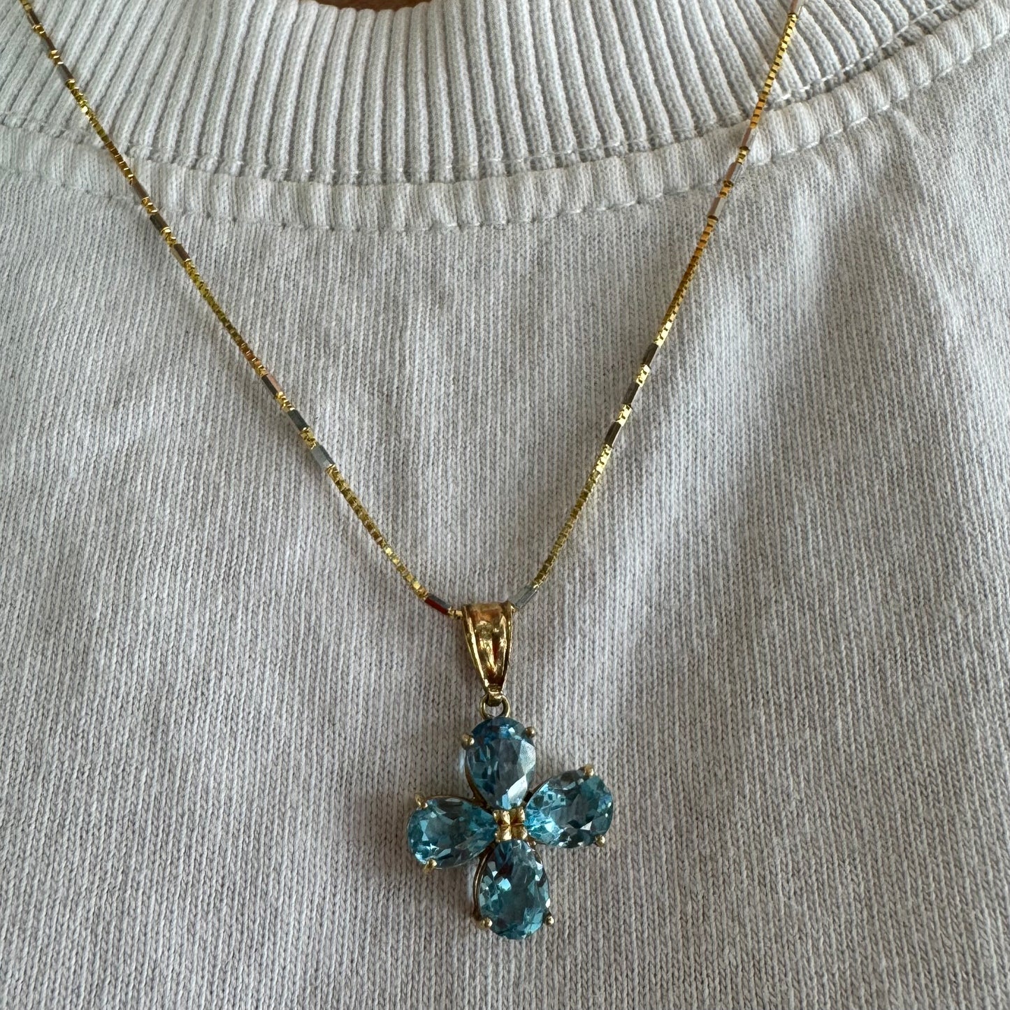 14K gold necklace with a cheerful floral pendant crafted from four pear-shaped Blue Topaz gemstones, arranged in a radiant blossom design