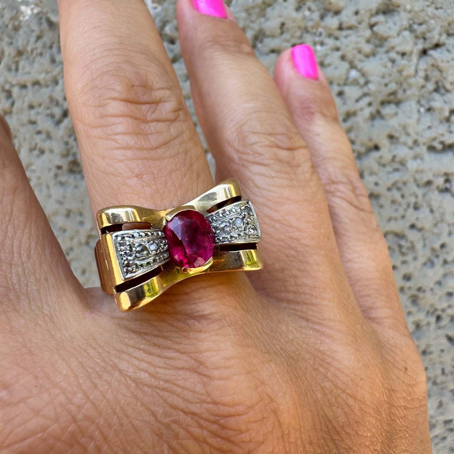 18K gold ring in a sculptural bow-inspired design.
Set with a vivid oval-cut Ruby at the center, framed by shimmering Diamonds