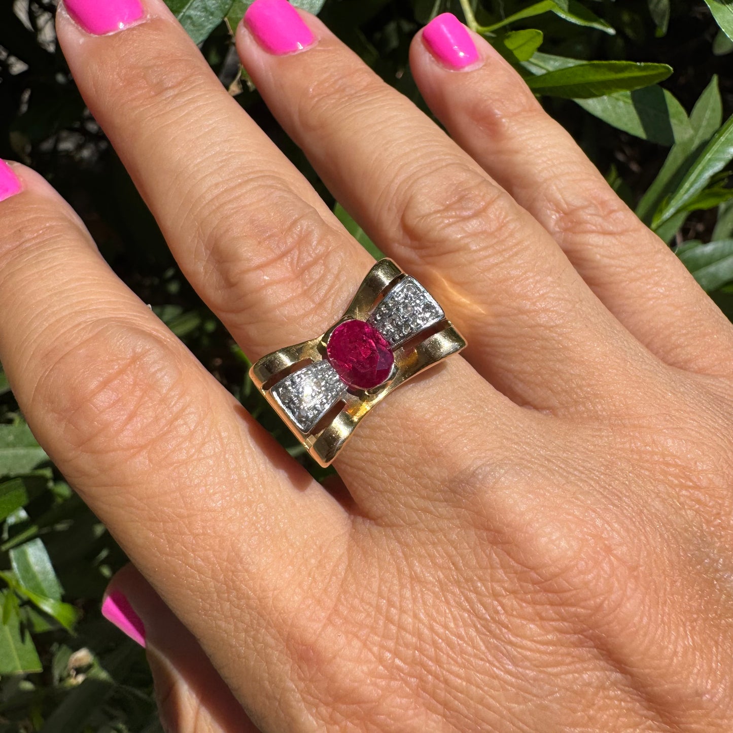 18K gold ring in a sculptural bow-inspired design.
Set with a vivid oval-cut Ruby at the center, framed by shimmering Diamonds