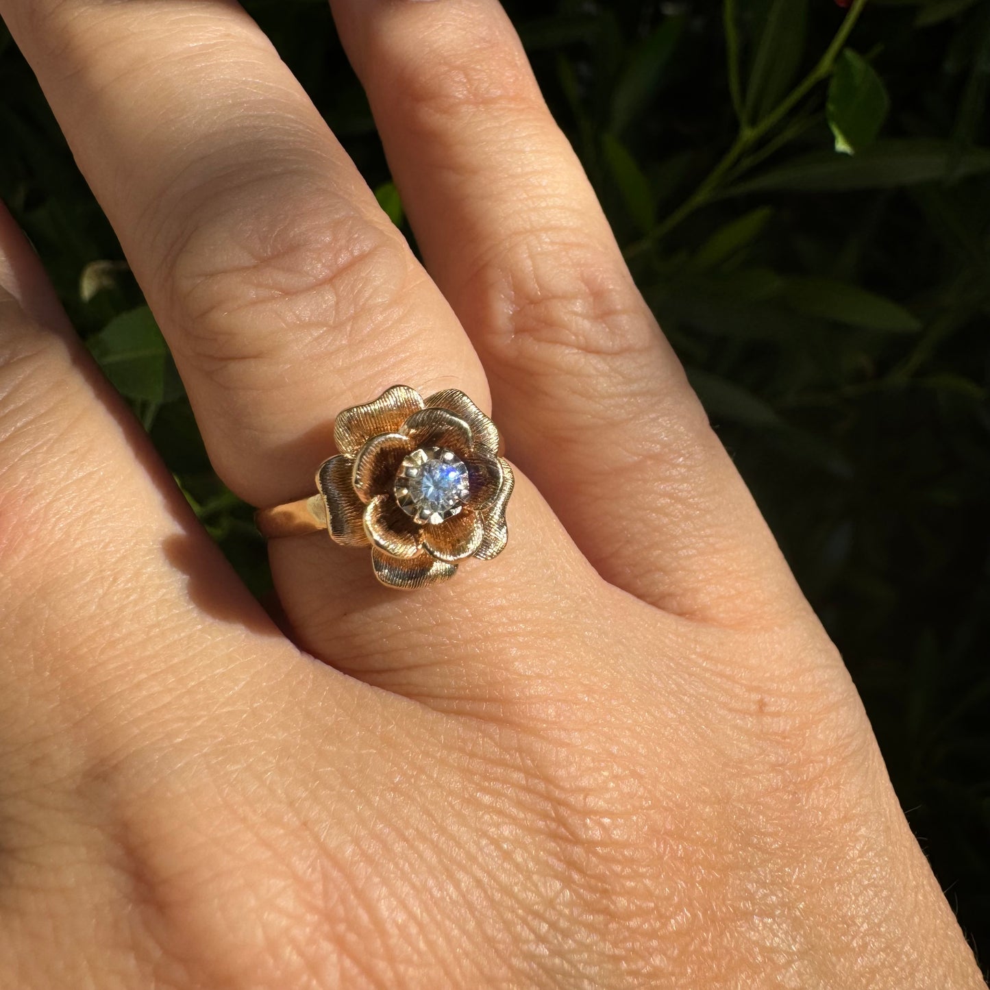 טבעת זהב צהוב 14 קראט בעיצוב פרח תלת־ממדי מזהב עם עלי כותרת טקסטורליים ועדינים במיוחד ובמרכזם משובץ יהלום – שמוסיף ברק רומנטי וקסום.