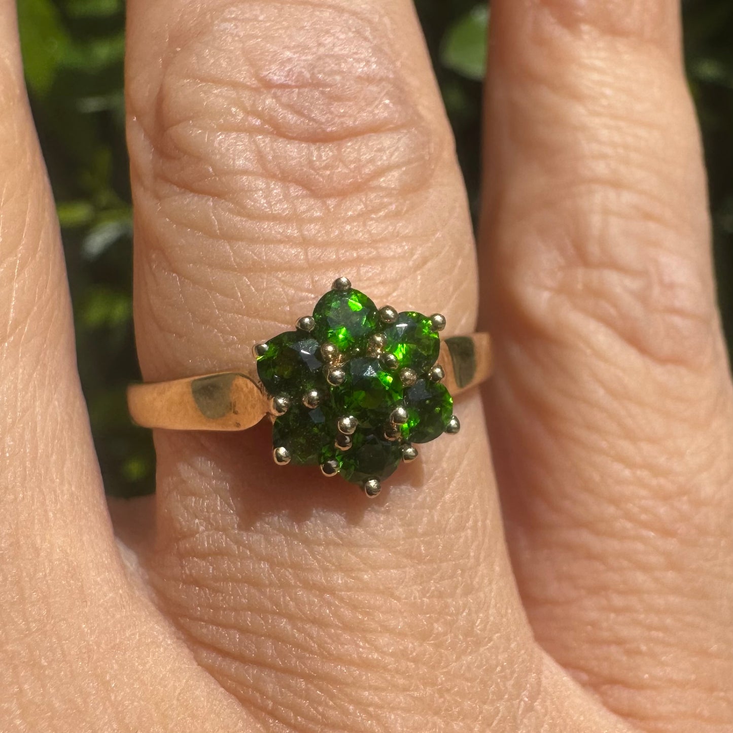 10K gold ring set with vivid green gemstones in a delicate floral cluster