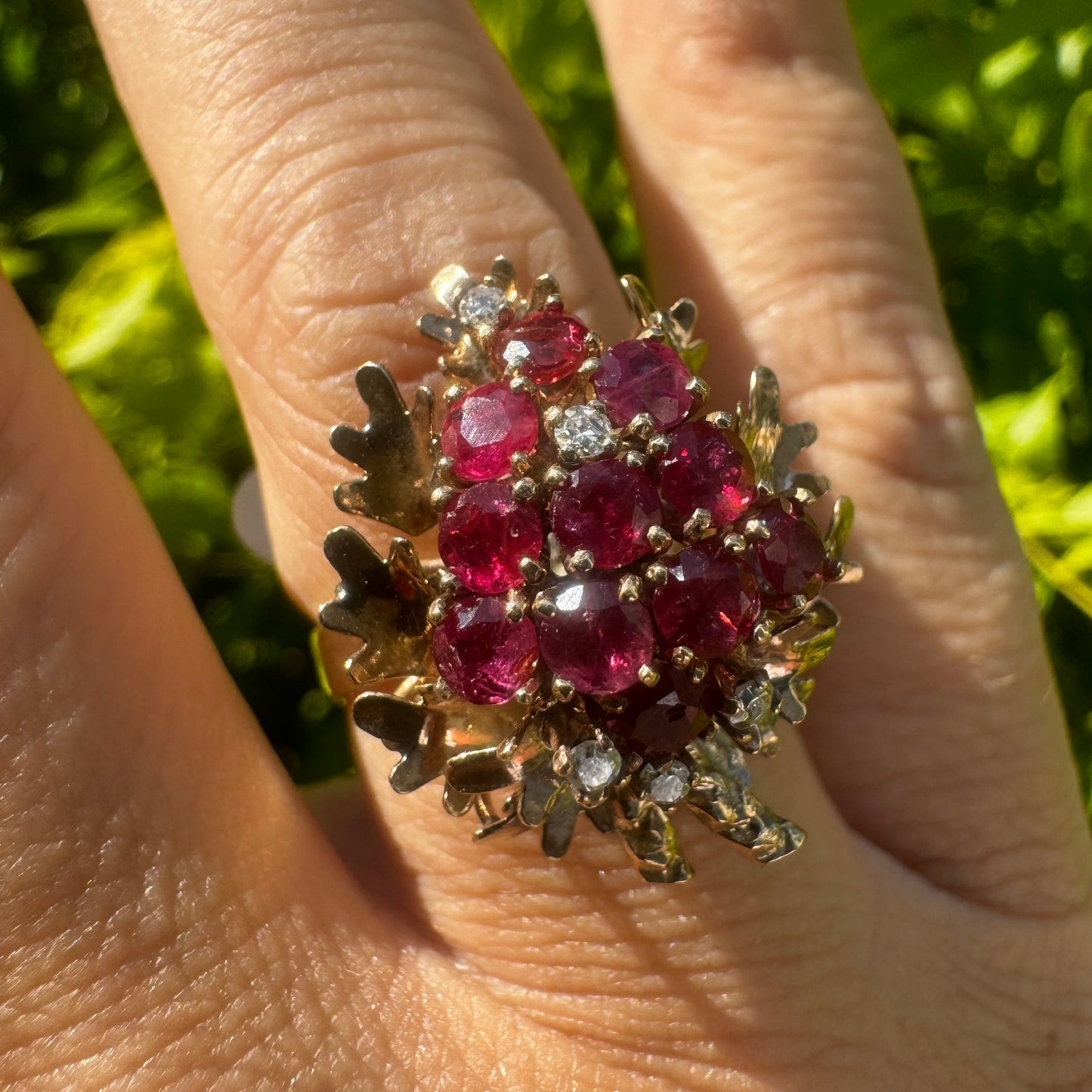 14K gold ring set with a vibrant cluster of deep red rubies and sparkling diamonds.