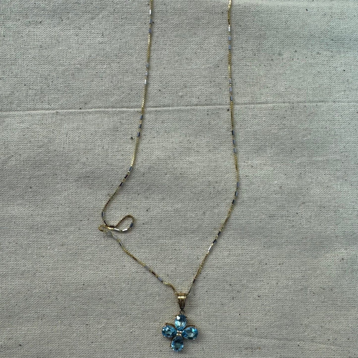 14K gold necklace with a cheerful floral pendant crafted from four pear-shaped Blue Topaz gemstones, arranged in a radiant blossom design