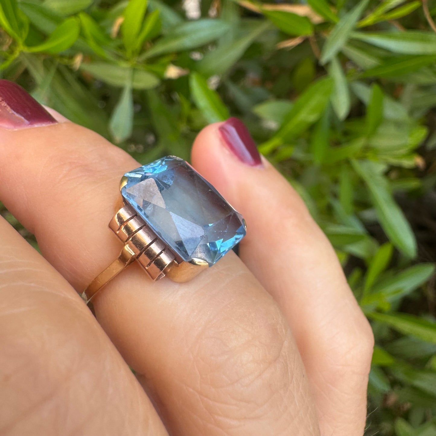 18K gold ring featuring a large rectangular Blue Topaz in a bezel setting with decorative side details.