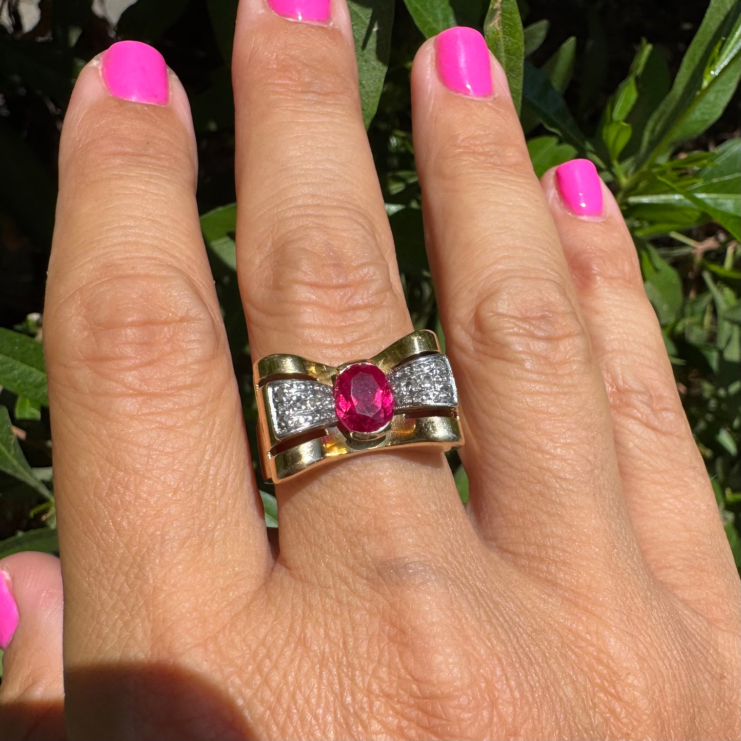 18K gold ring in a sculptural bow-inspired design.
Set with a vivid oval-cut Ruby at the center, framed by shimmering Diamonds
