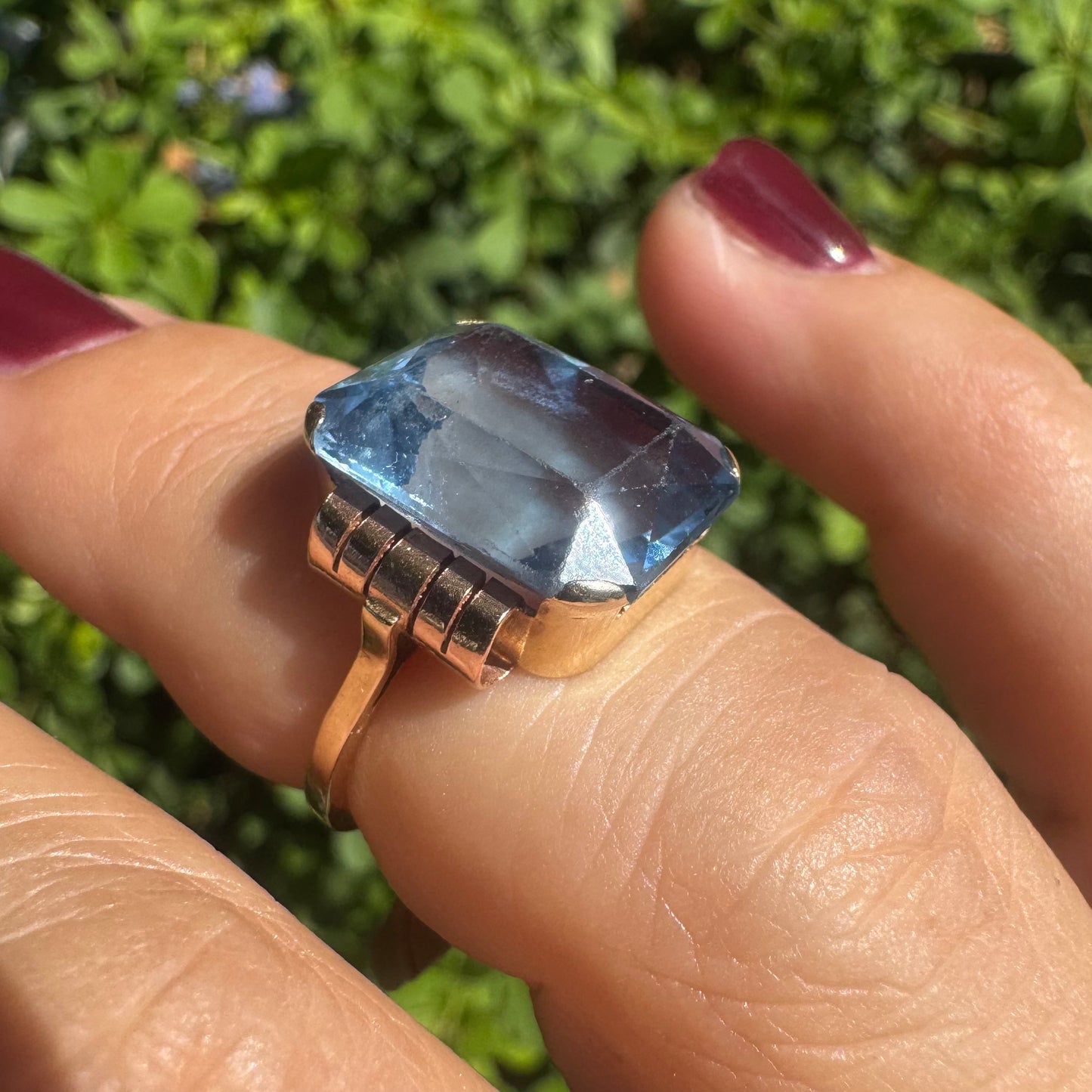 18K gold ring featuring a large rectangular Blue Topaz in a bezel setting with decorative side details.
